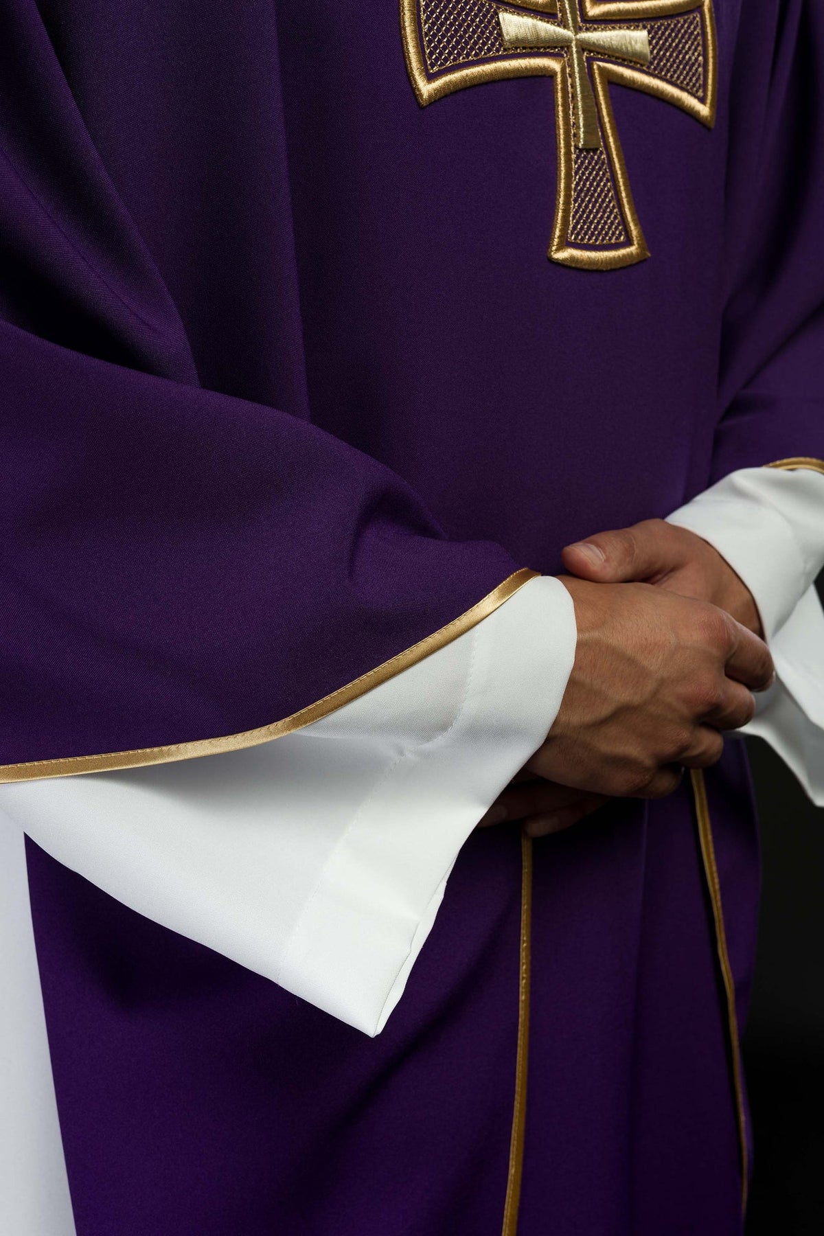 Purple chasuble close-up showing gold trim on sleeve and edge