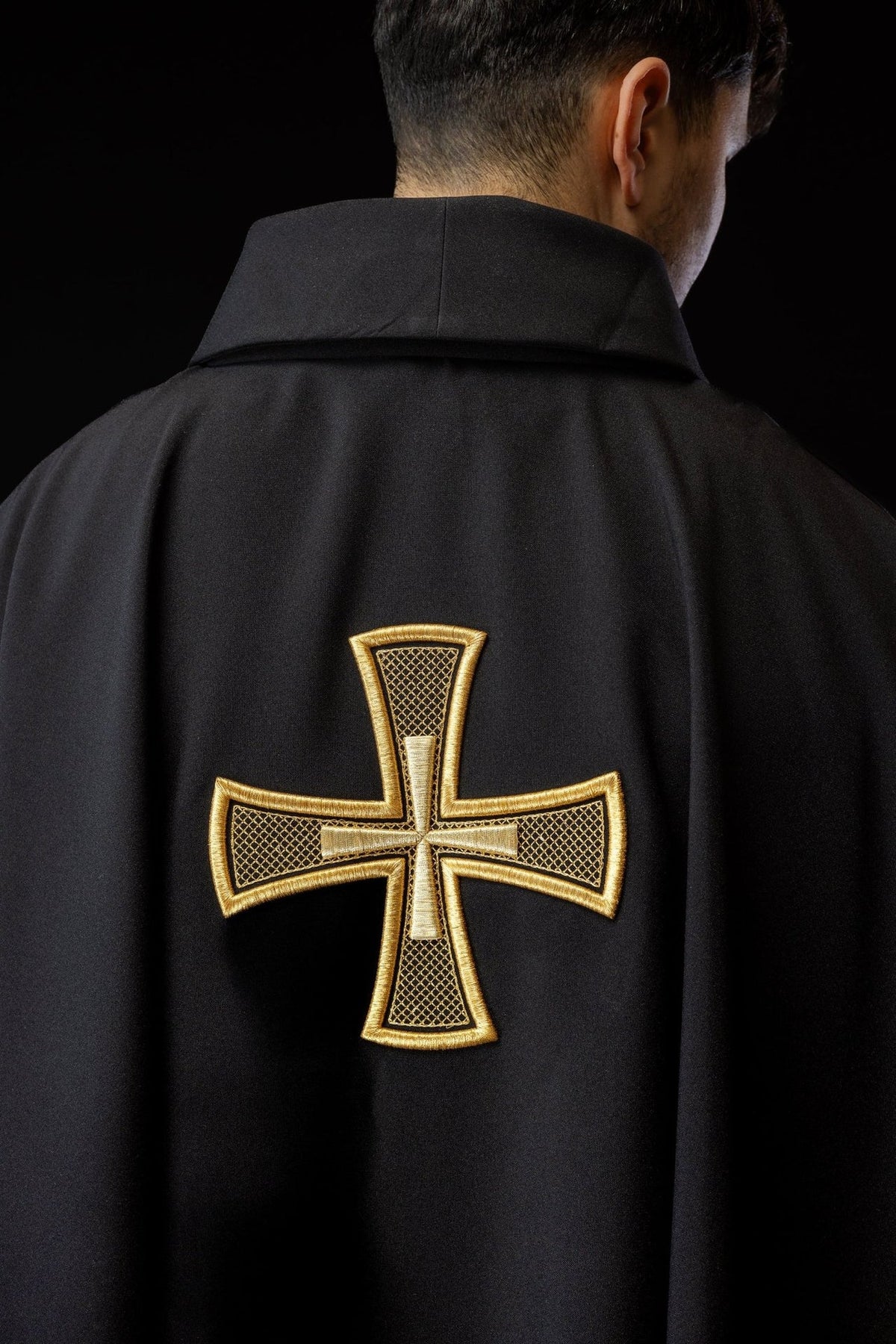 Black chasuble back close-up with large gold cross embroidery