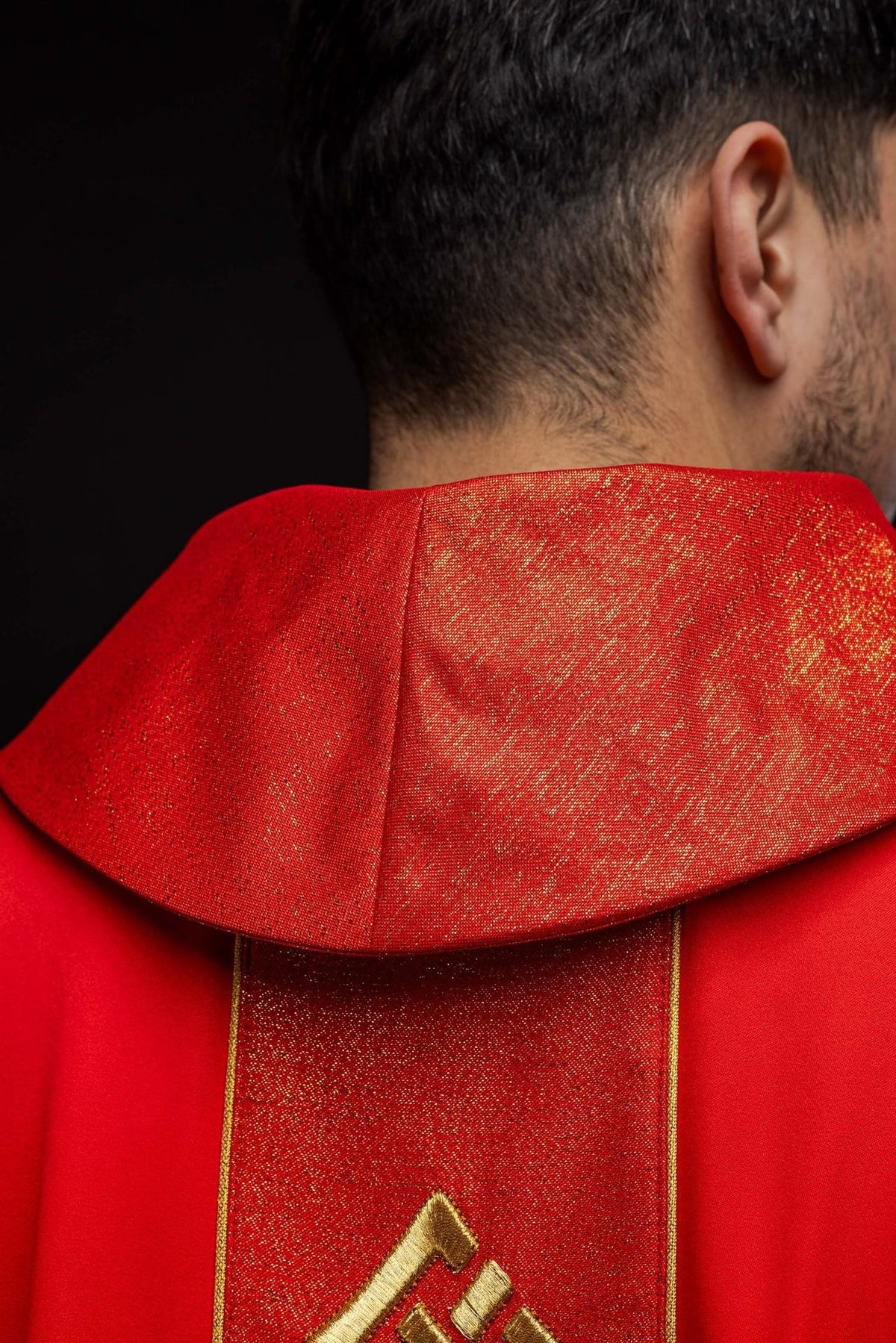 Red chasuble side detail showing gold trim and satin central panel