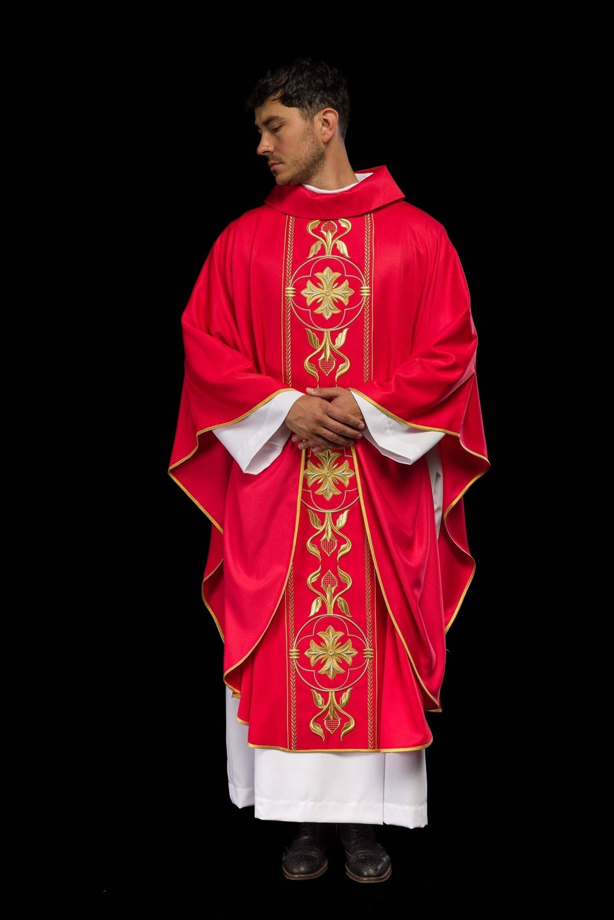 Red chasuble worn front view showing wide sleeves and gold embroidered orphrey