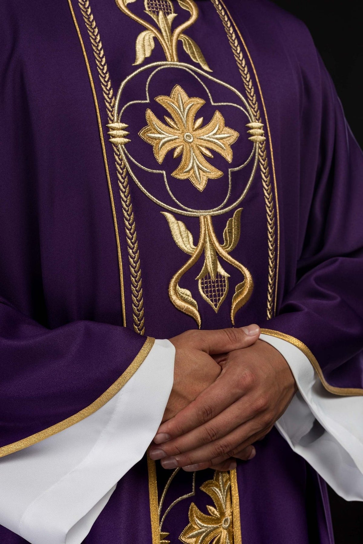 Purple chasuble close-up showing gold embroidered floral orphrey and sleeve trim