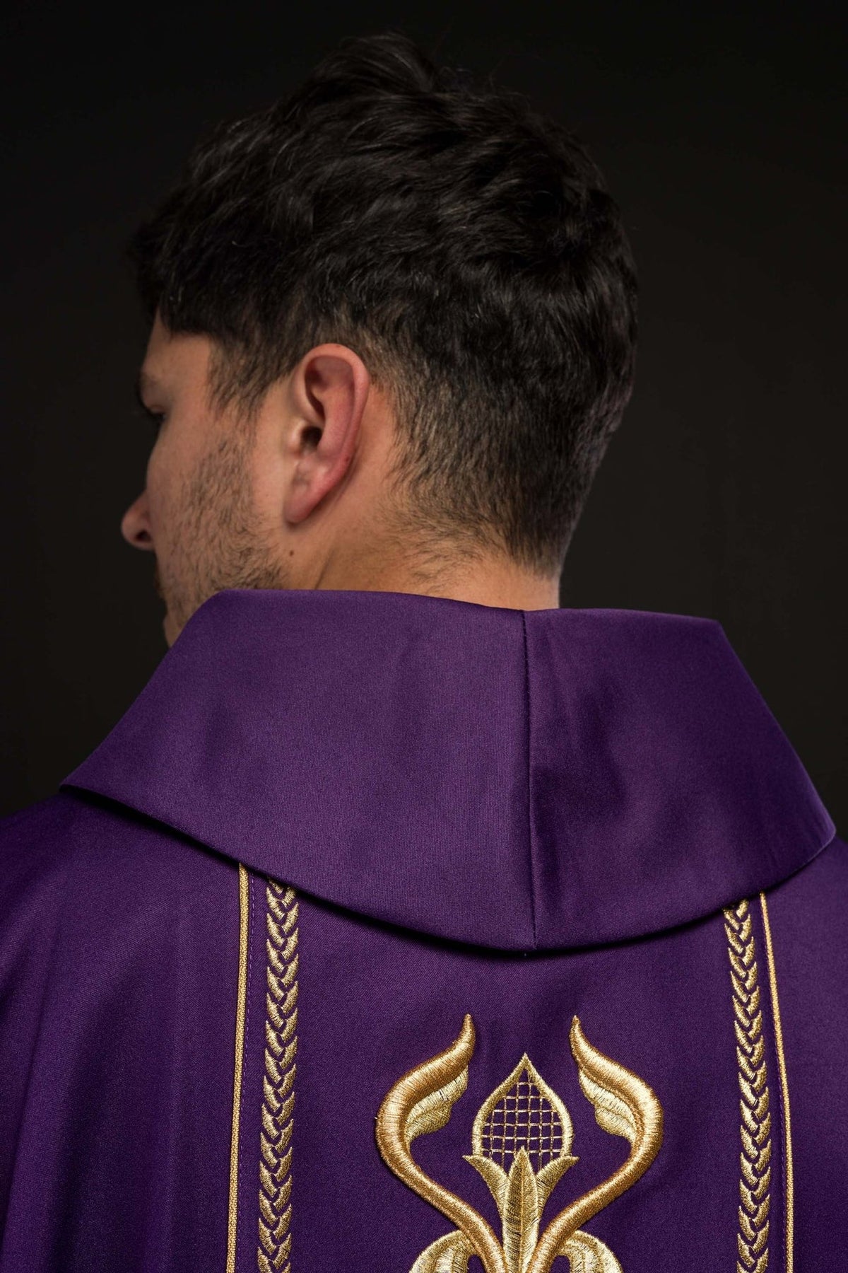Purple chasuble back close-up showing gold floral embroidery and braided orphrey trim