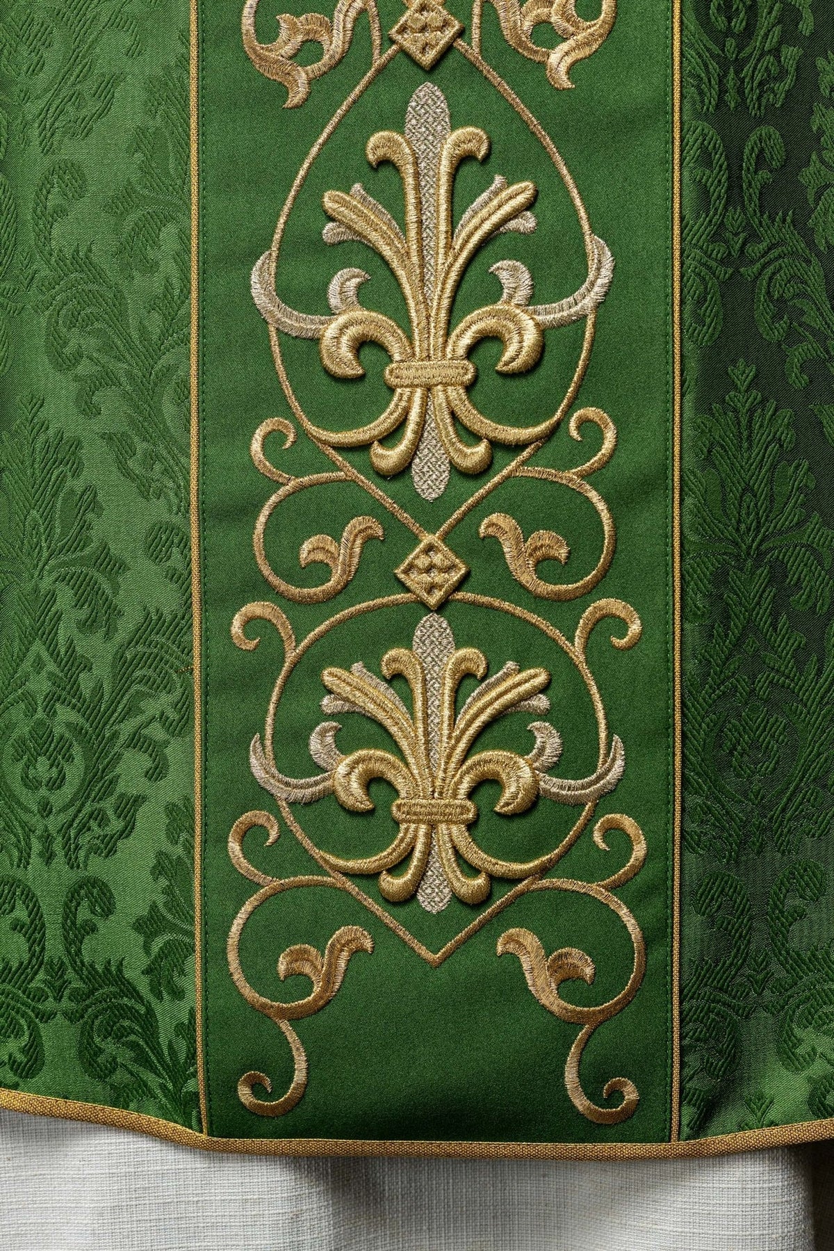 Green chasuble detail showing satin floral fabric and gold trim