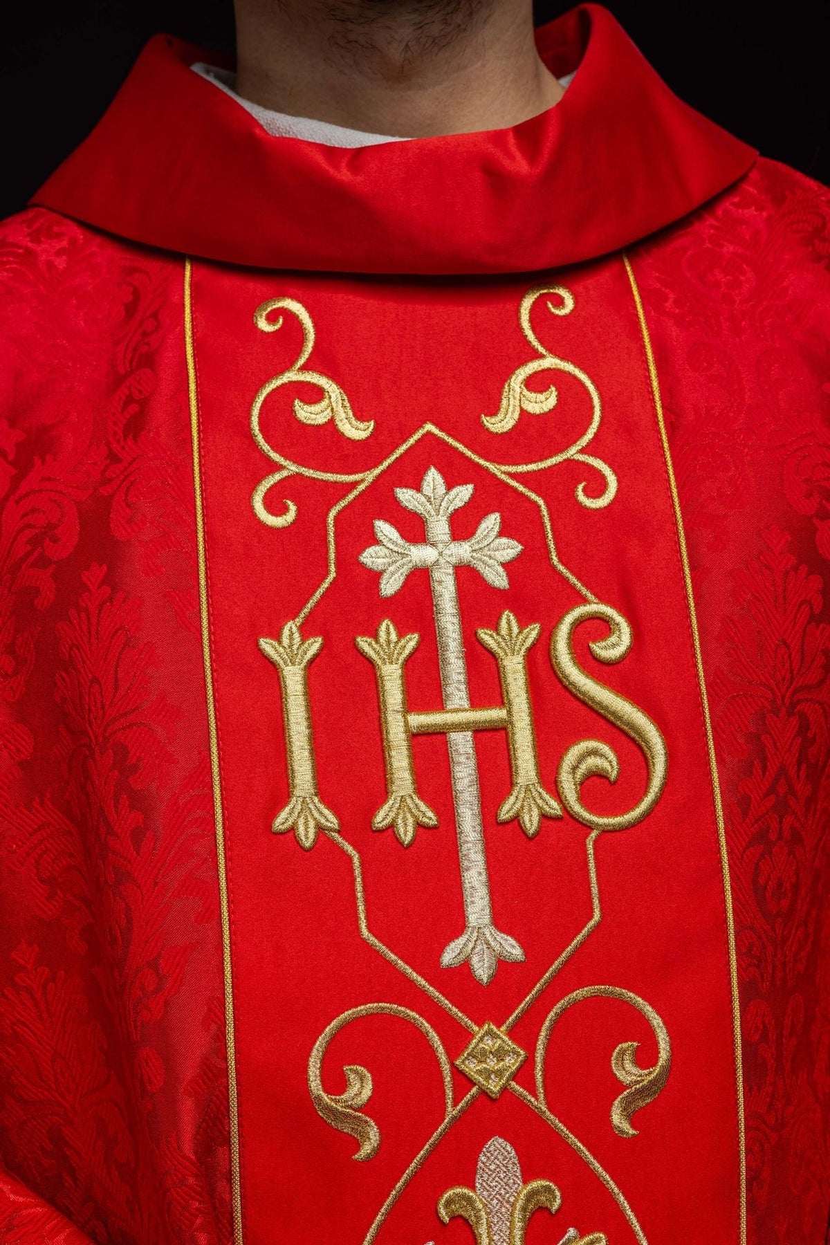Red chasuble, close-up of embroidered IHS and cross on the front