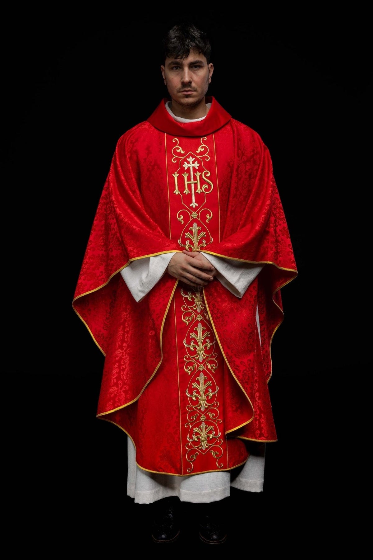 Red chasuble, full front view showing the patterned fabric and embroidered panel