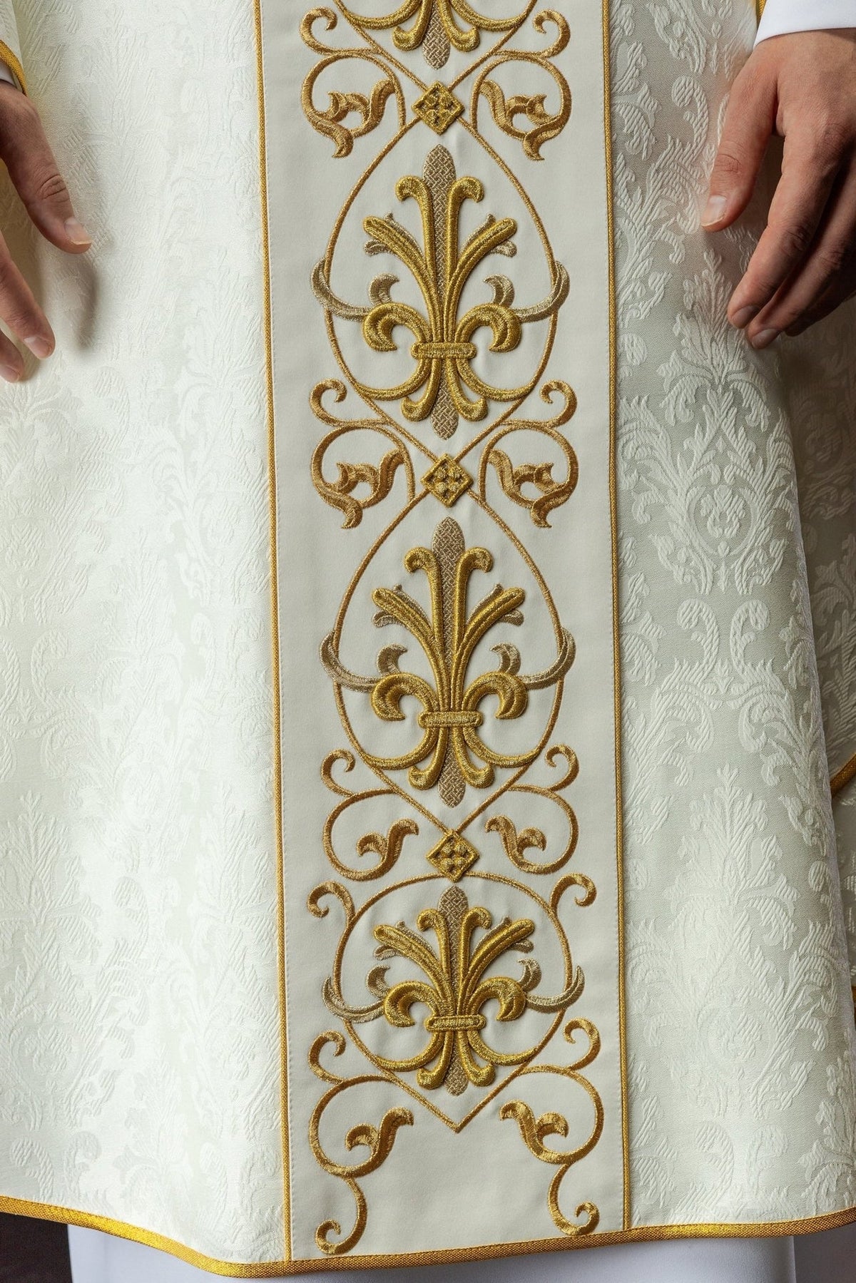 Ecru chasuble front close-up showing repeated gold fleur-de-lis embroidery