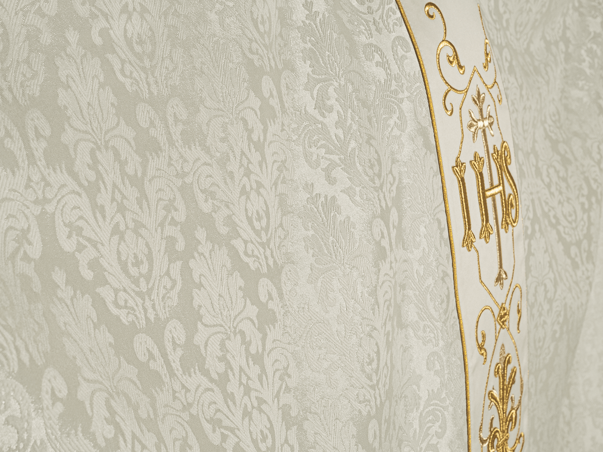 Ecru chasuble worn from the back and side with gold embroidered panel