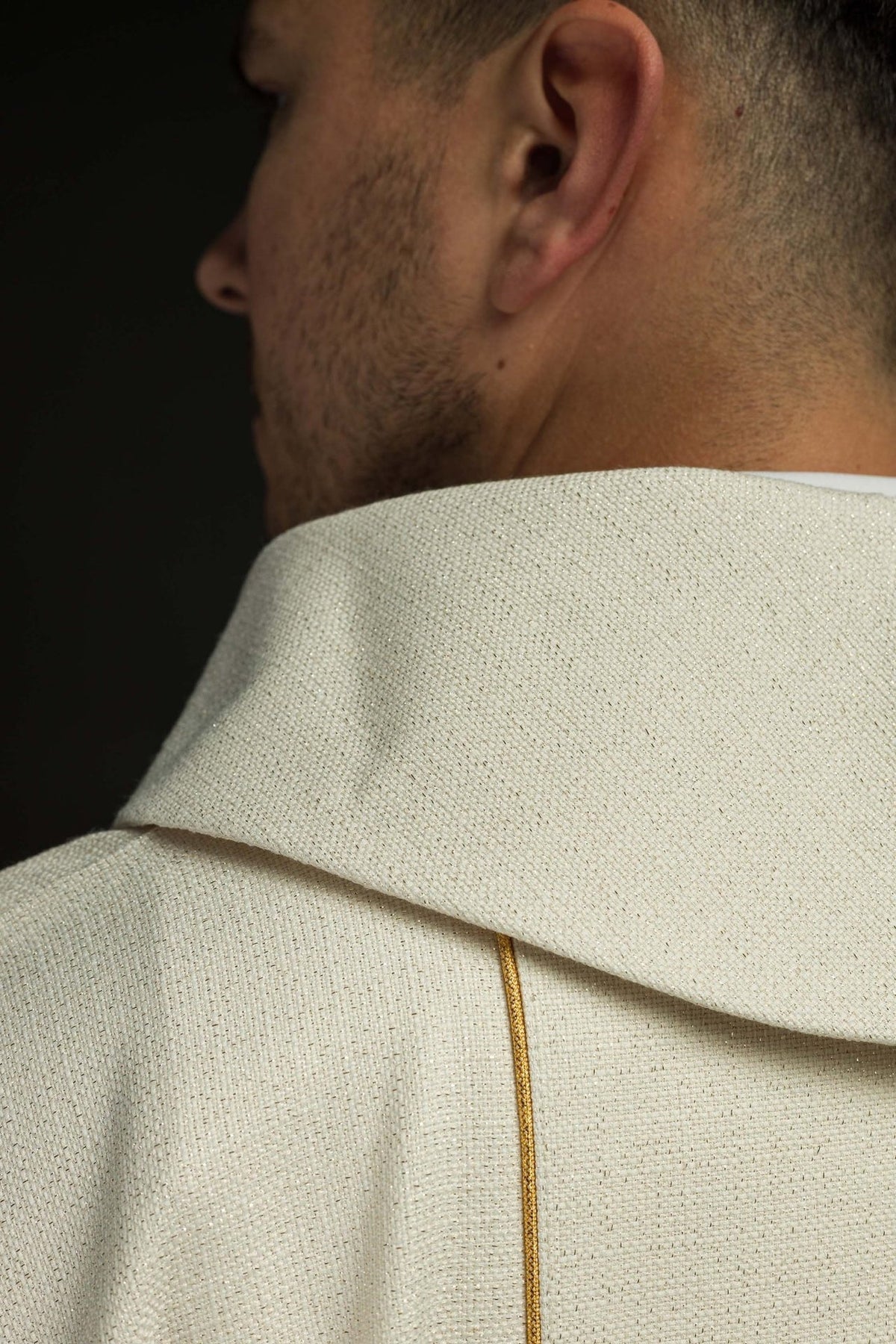 Christmas chasuble close-up of ivory fabric, stand-up collar and gold trim on the back
