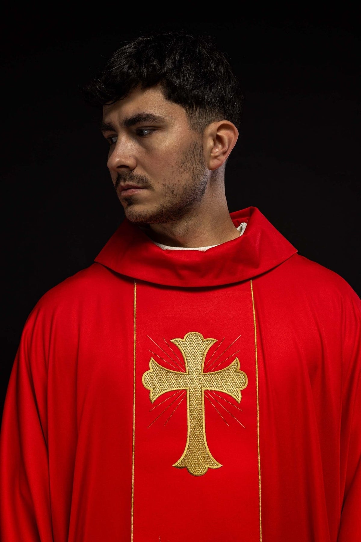 Red chasuble detail showing gold cross embroidery and trim
