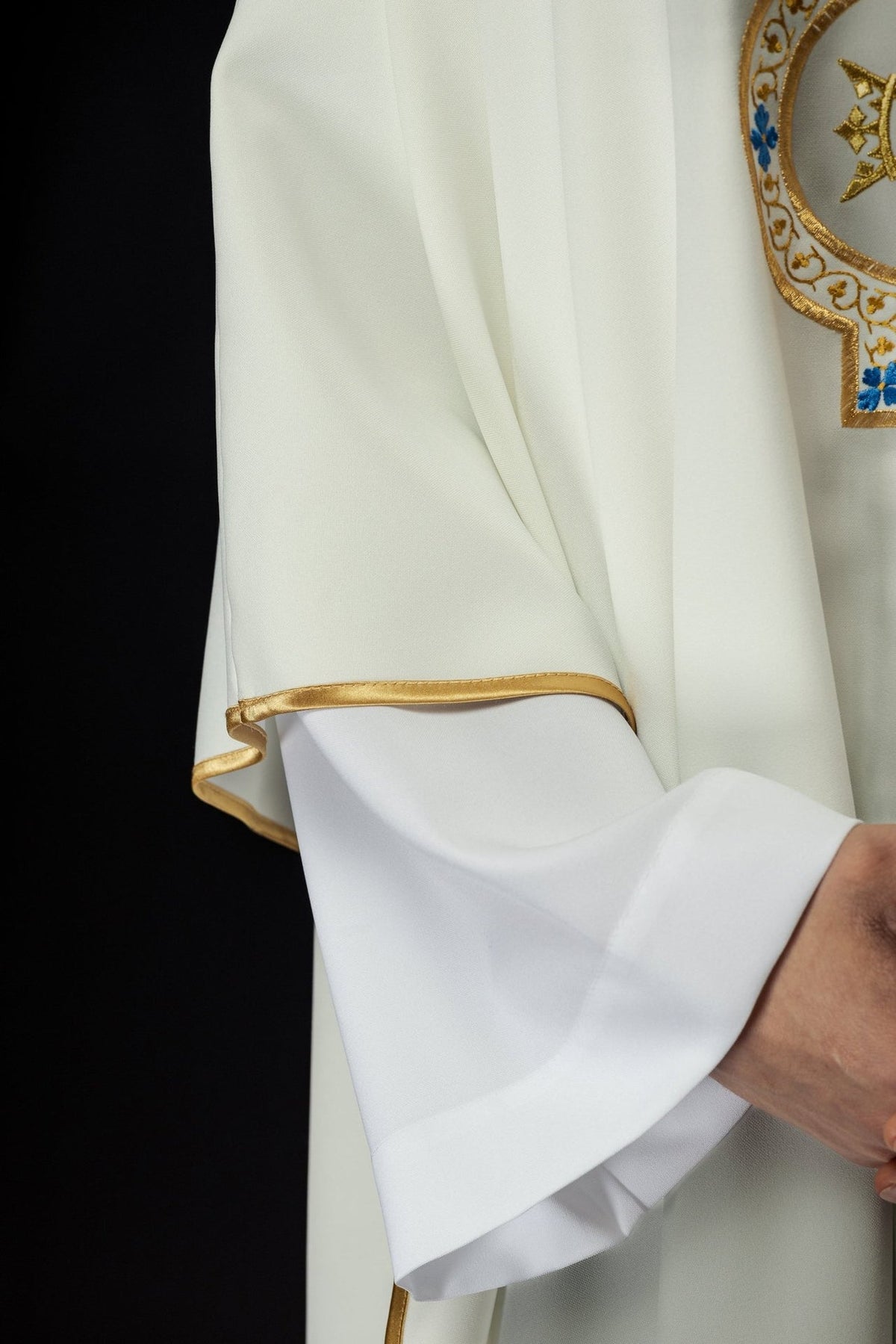 Ecru chasuble, side close-up showing gold trim on the sleeve edge