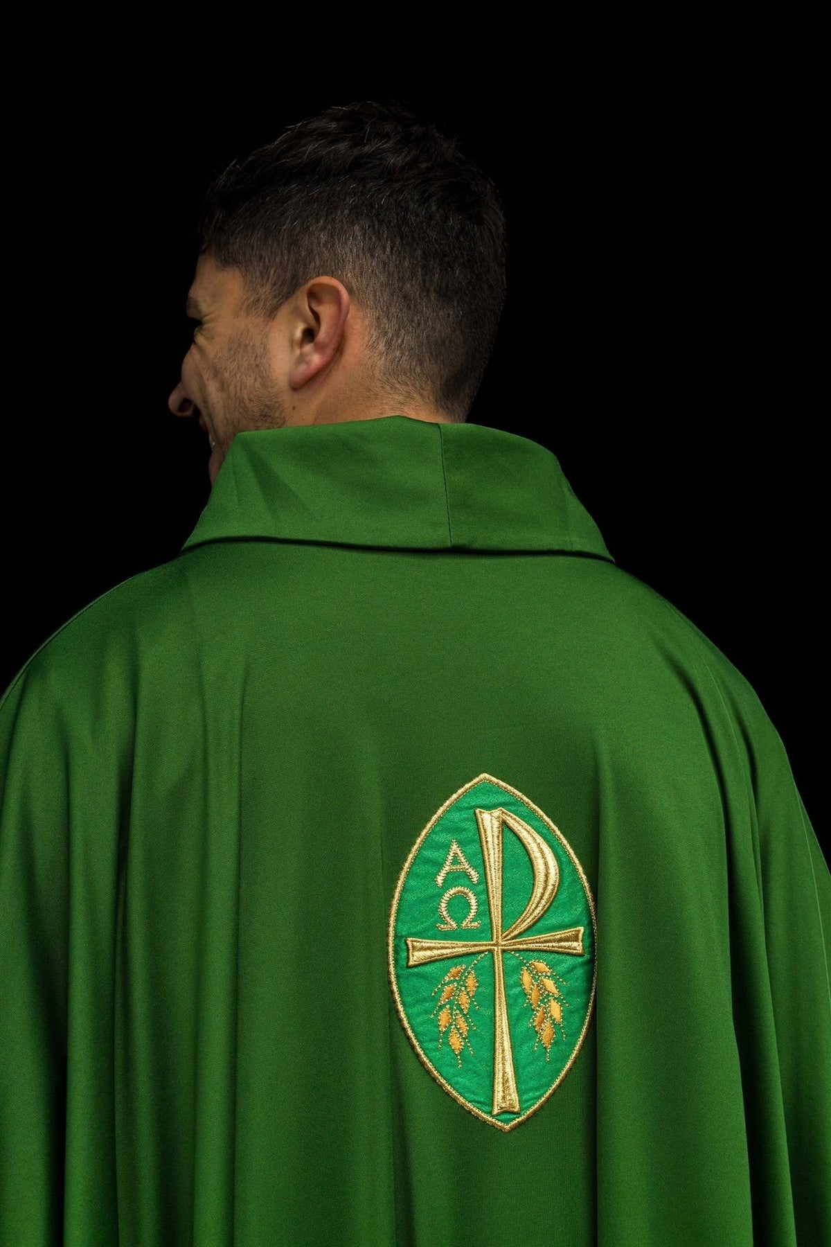 Green chasuble back worn view with gold embroidered cross emblem