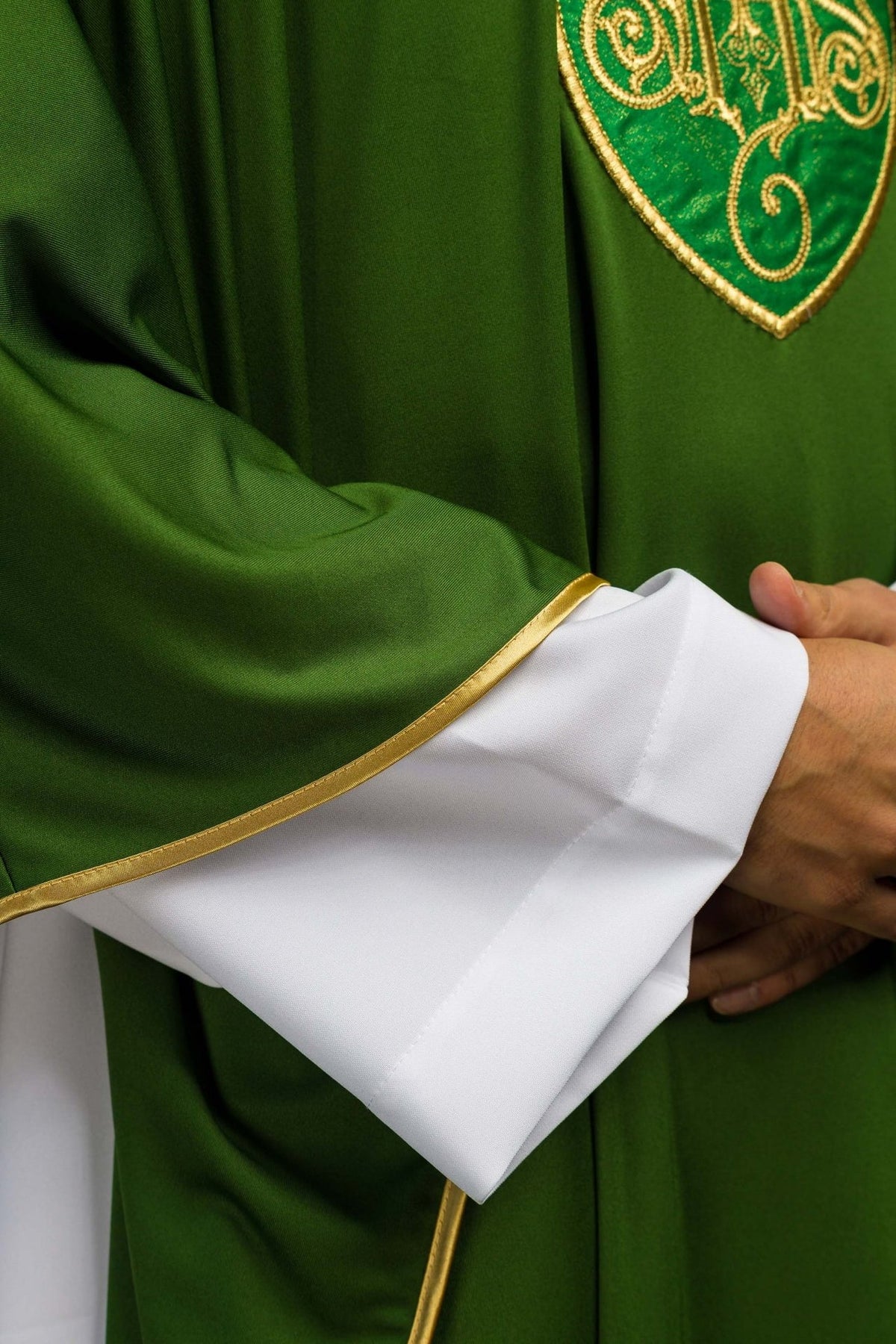 Green chasuble detail showing white inner stole and gold sleeve trim