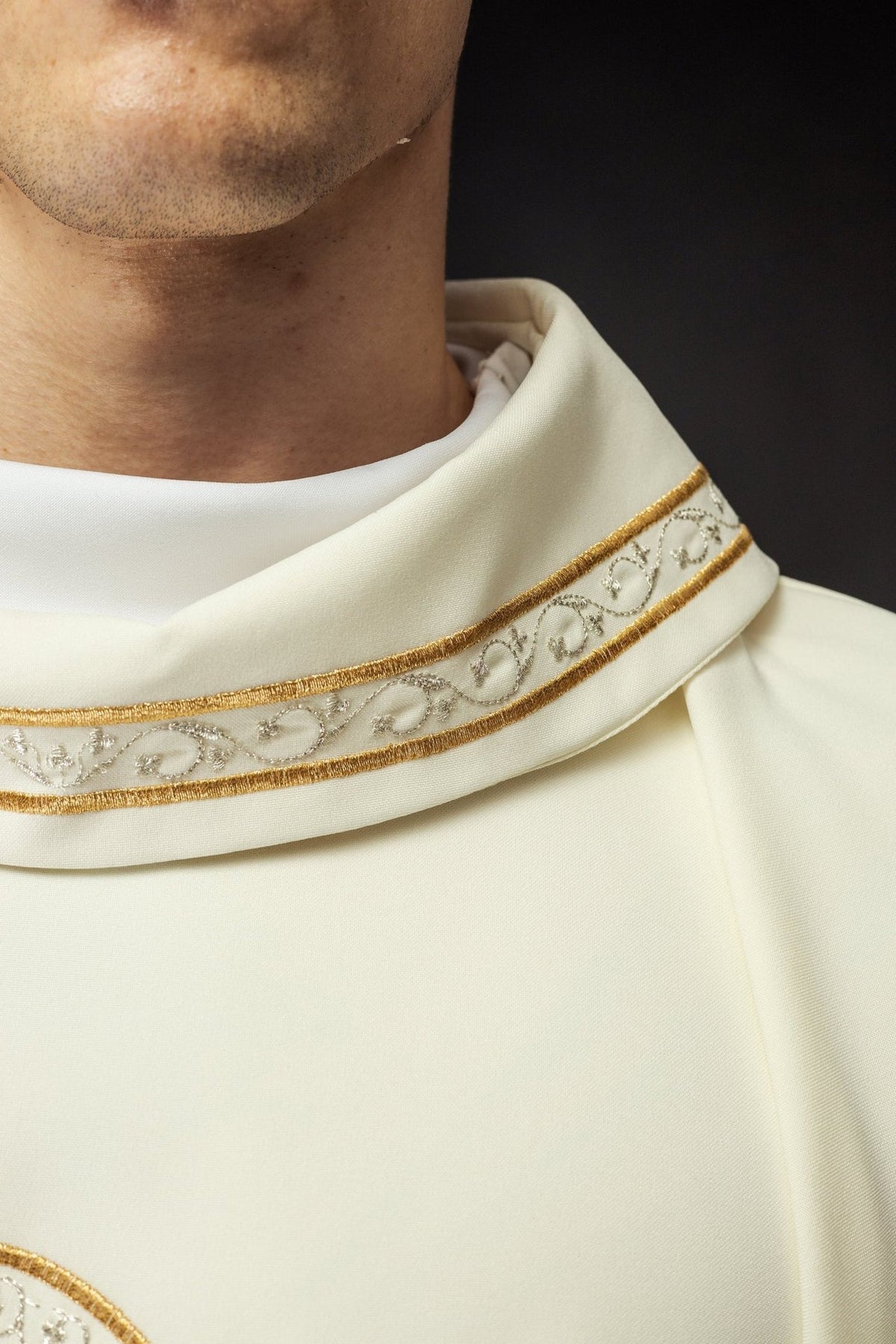 Ecru chasuble close-up of white fabric, stand-up collar and gold trim