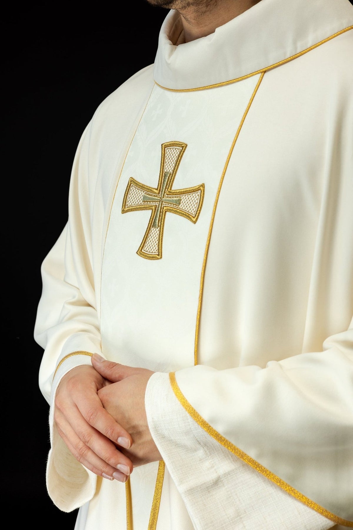 Catholic chasuble close-up showing embroidered gold cross and orphrey