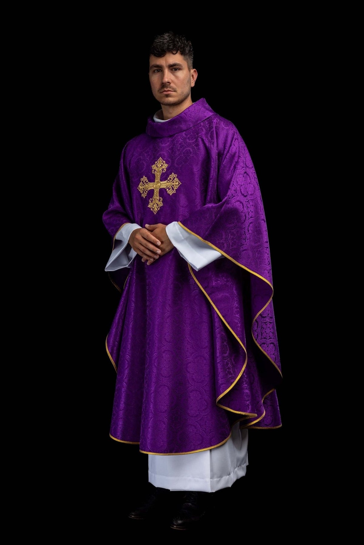 Purple chasuble worn angled front view with gold cross embroidery and flowing gold trim