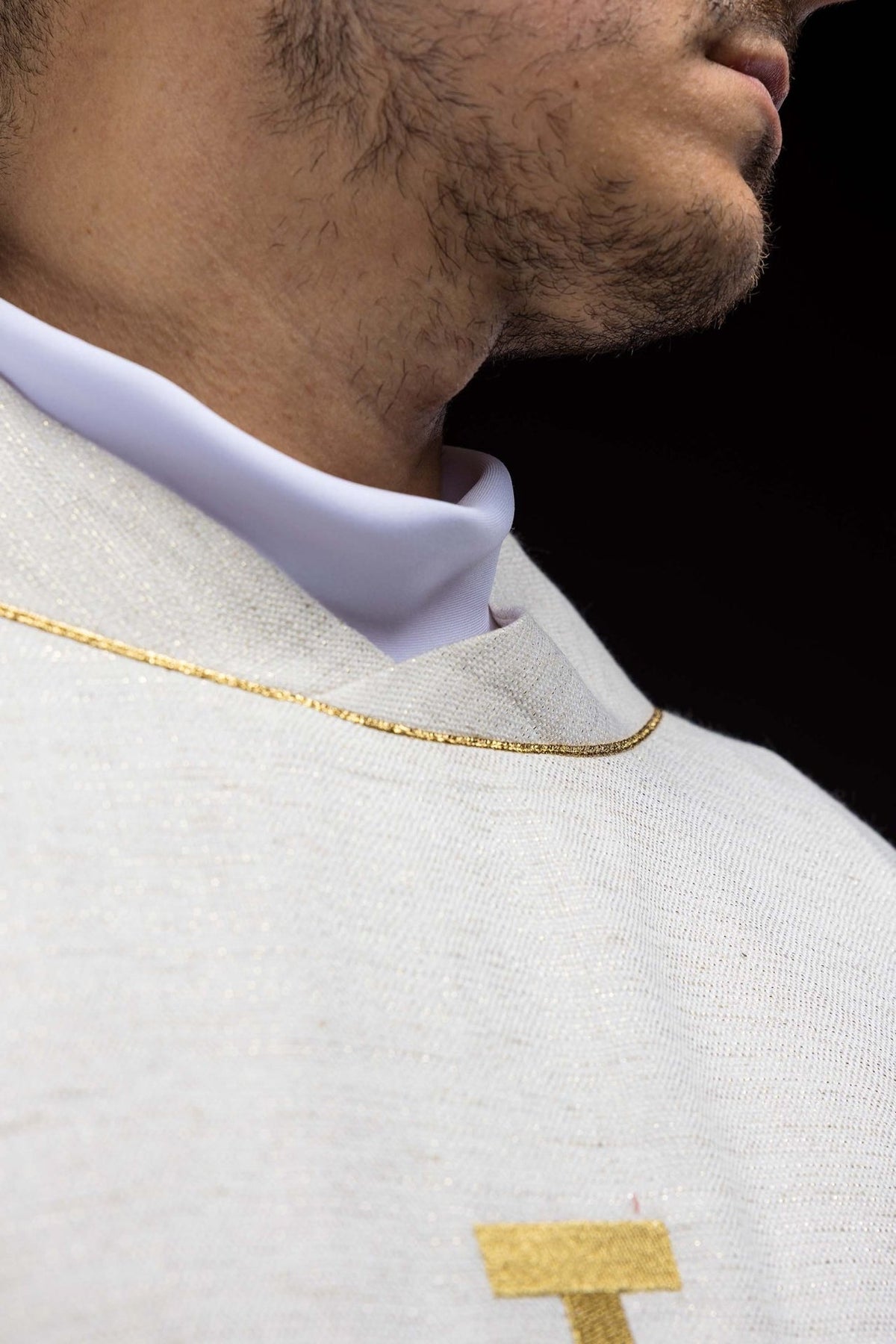 Chasuble neckline close-up with gold trim on ecru fabric