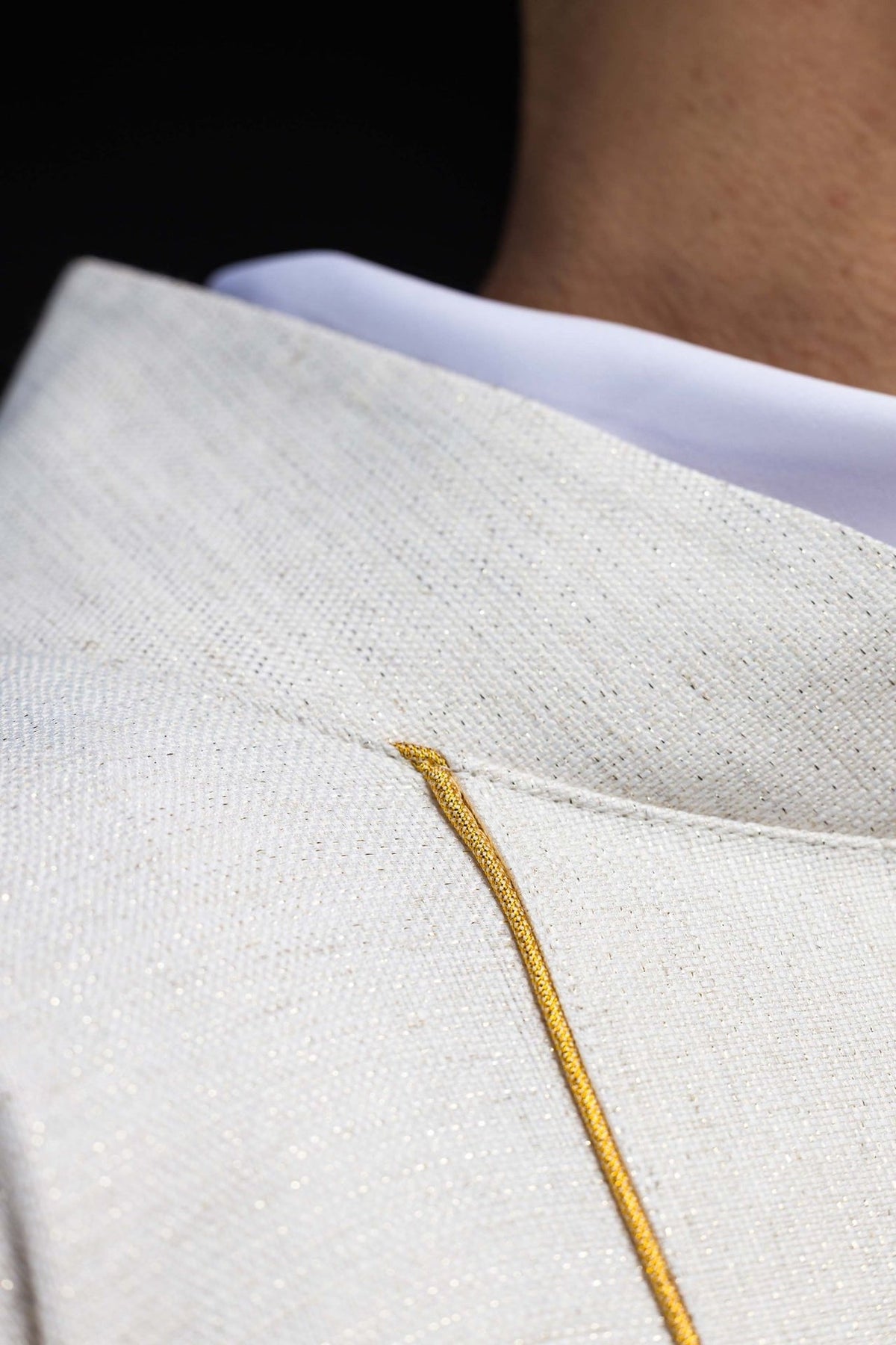 Close-up of embroidered ecru chasuble fabric and gold trim