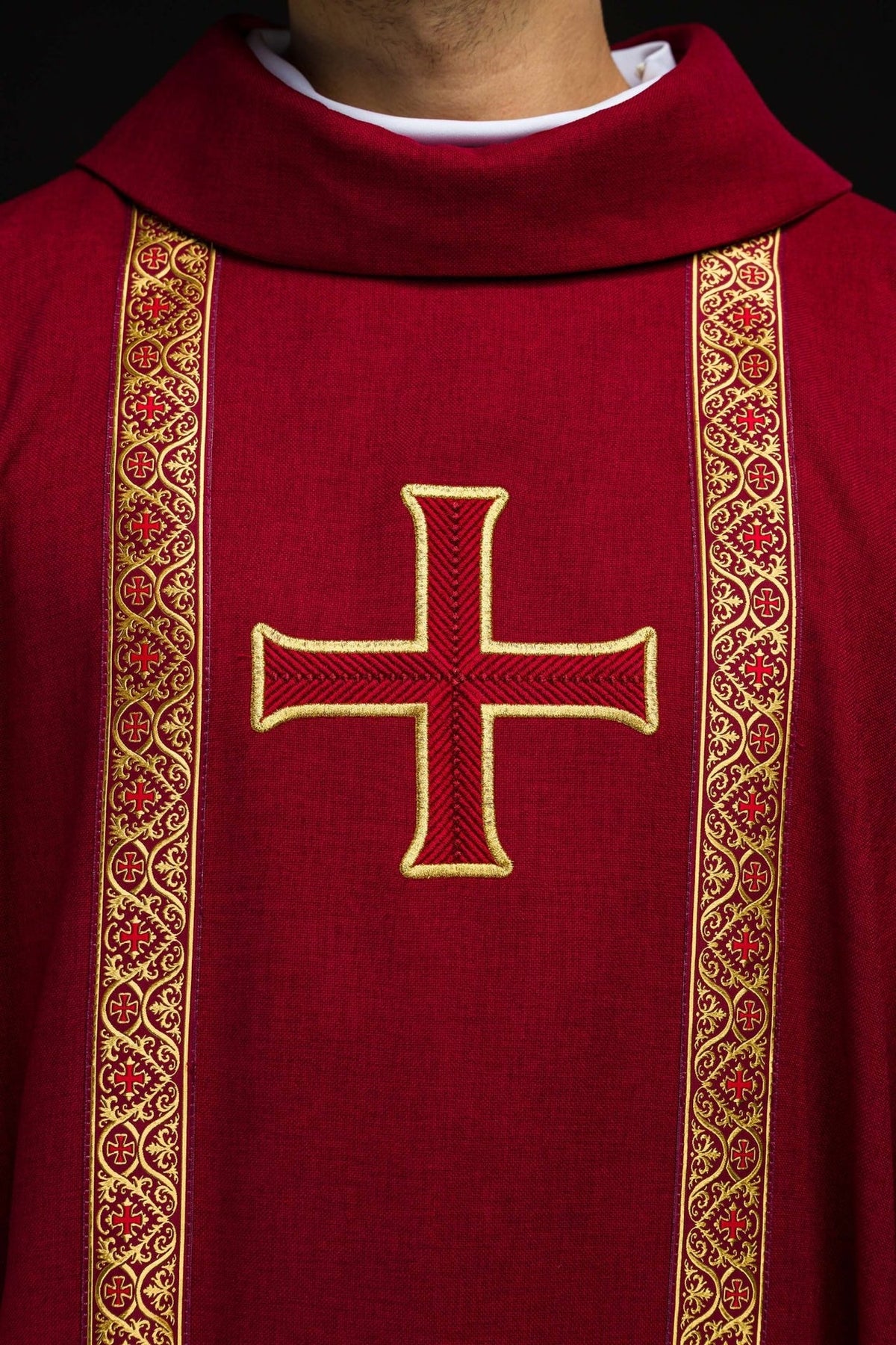 Red chasuble close-up showing embroidered gold cross and jacquard orphreys