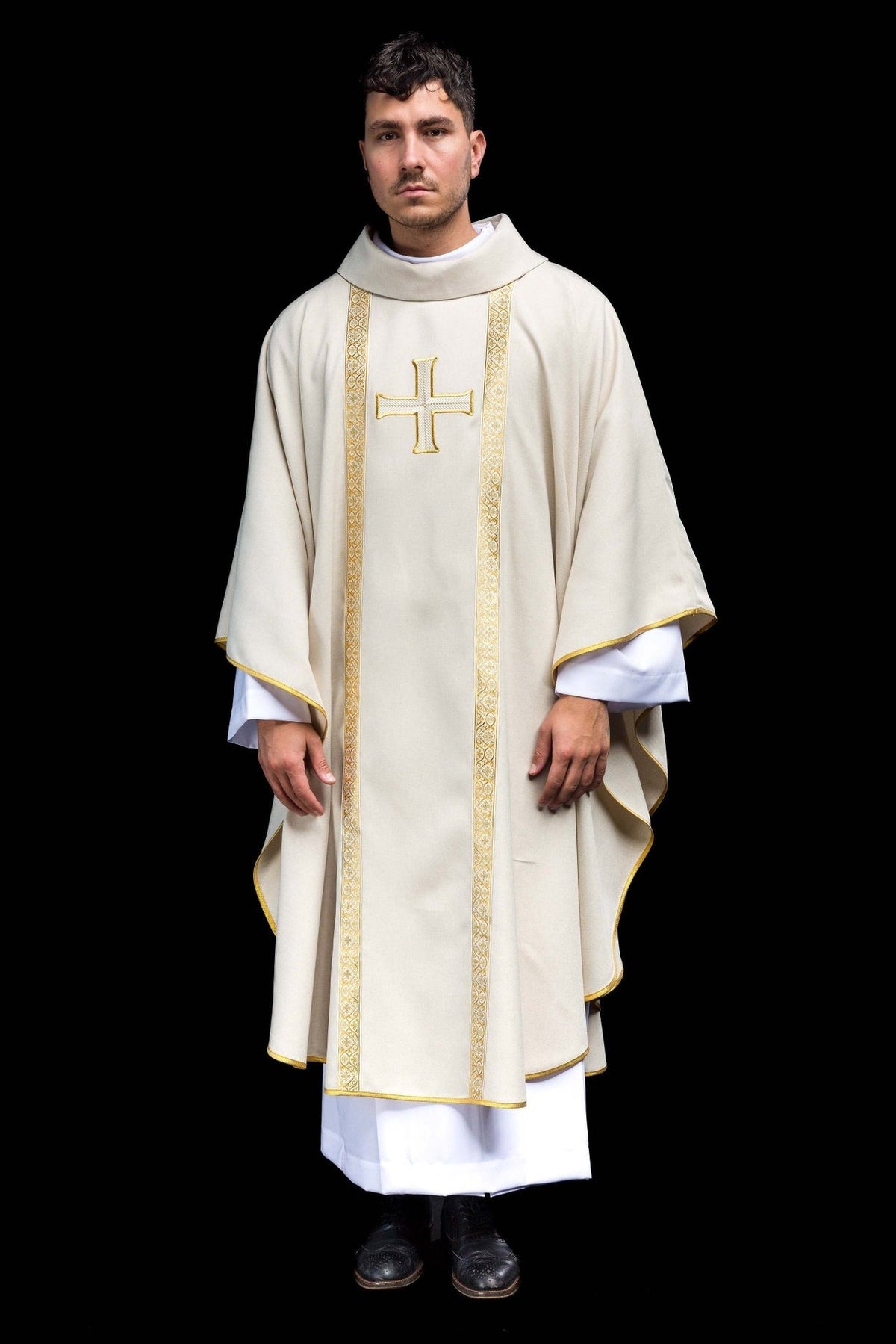 Ecru chasuble worn from the front, with gold cross embroidery and ornate orphrey trim