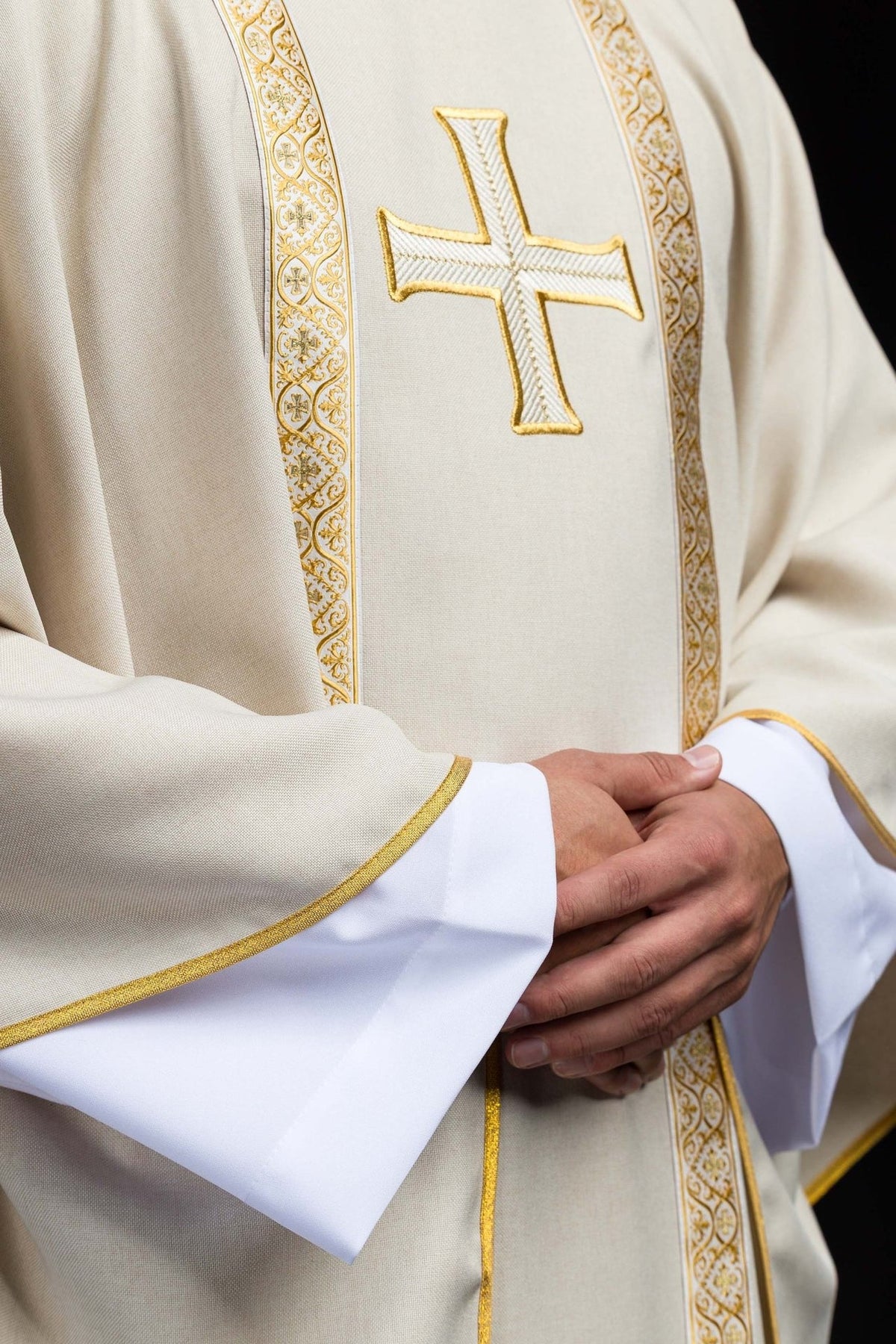 Ecru chasuble close-up showing gold-edged sleeves and front cross embroidery