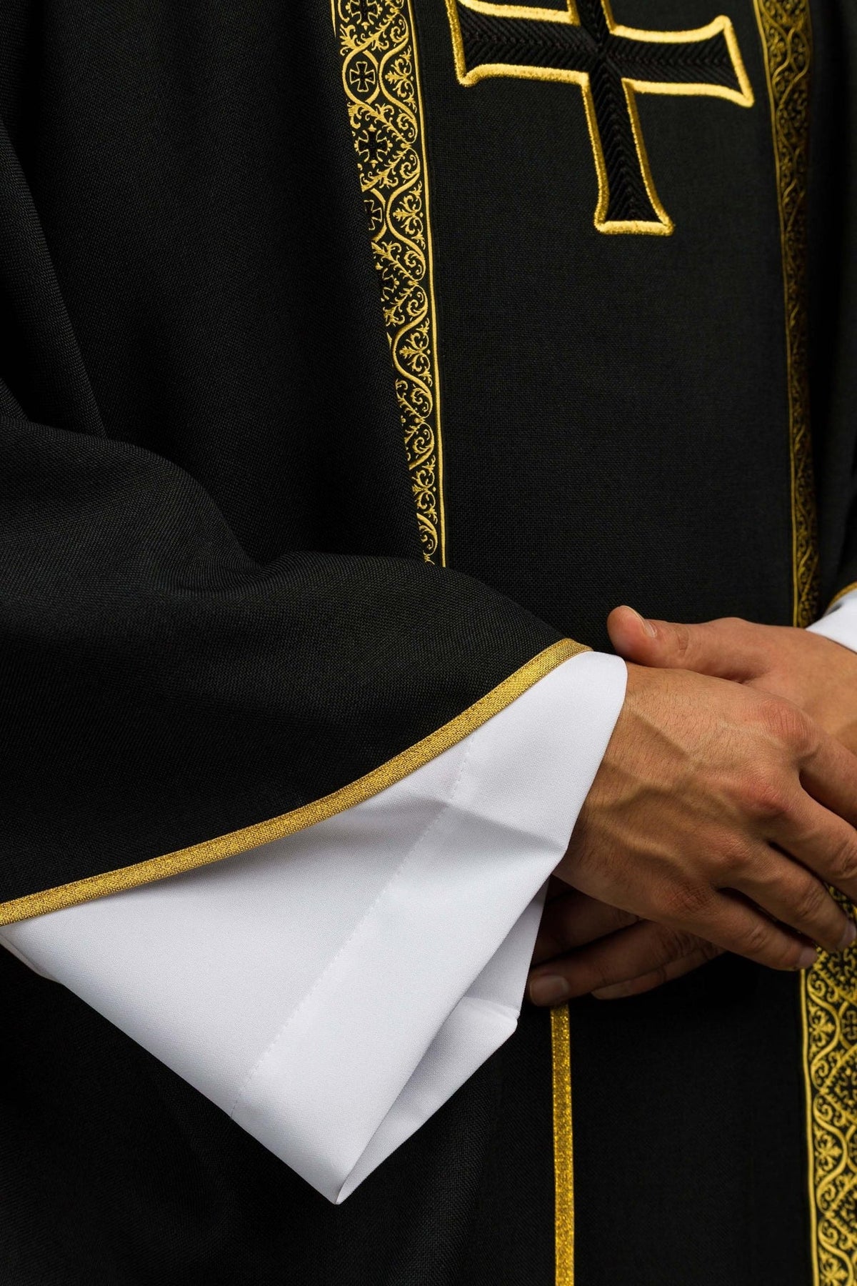 Black chasuble detail showing gold trim, jacquard orphrey and sleeve edge