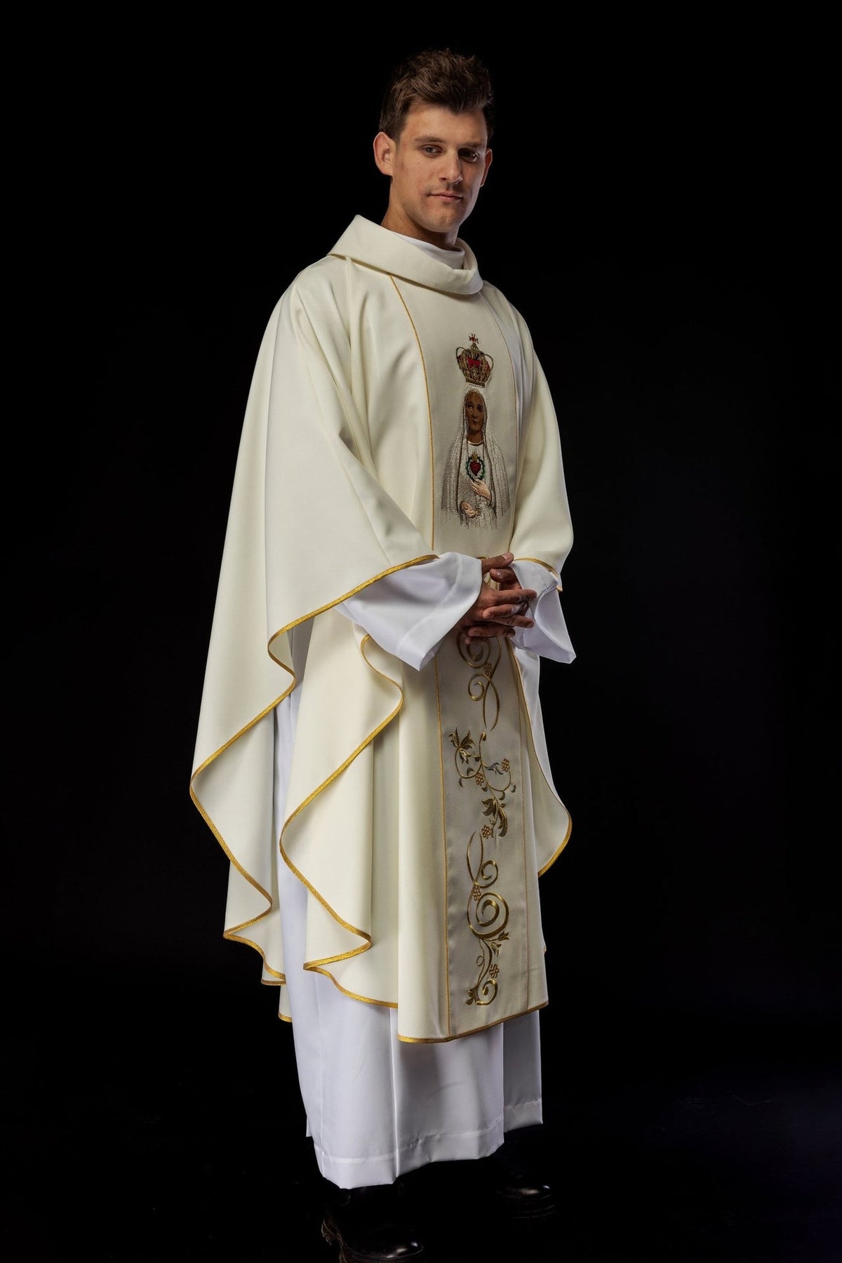 Chasuble side view showing flowing ivory fabric, gold trim and front embroidery