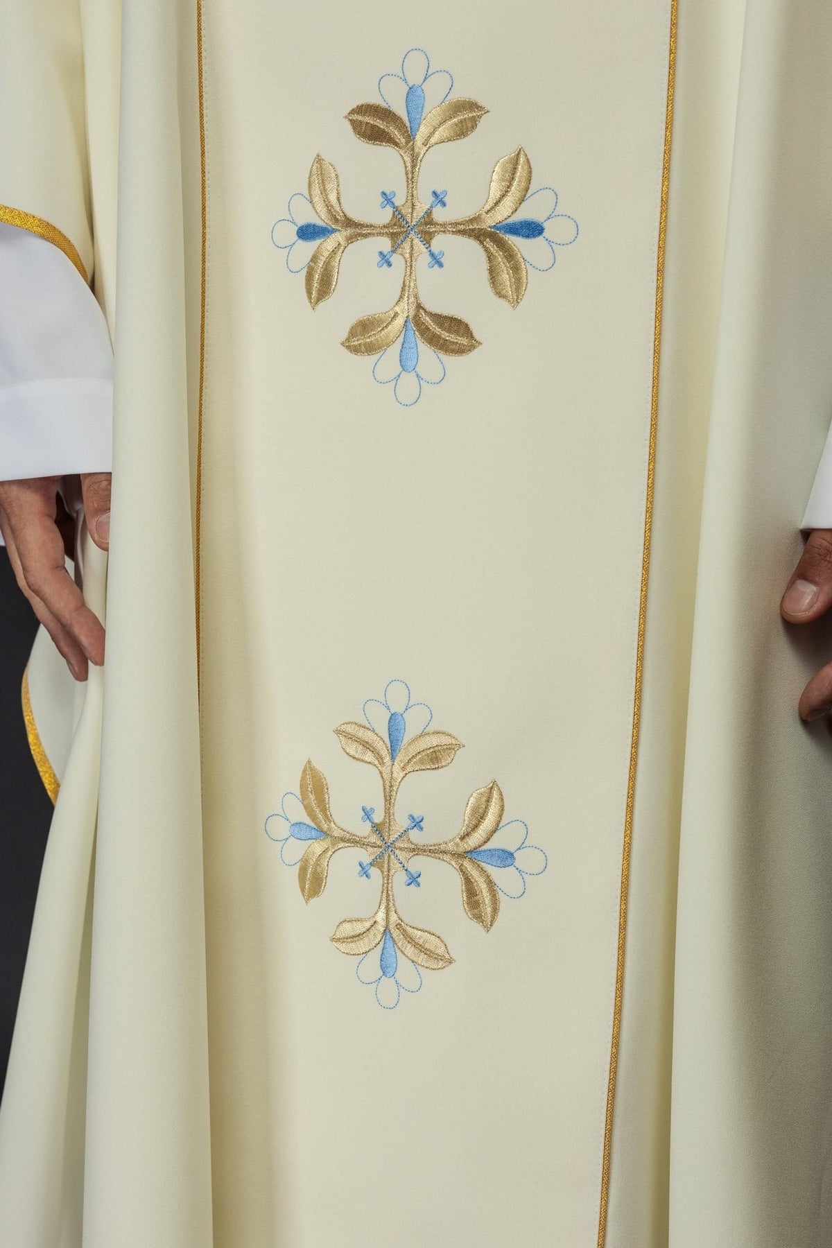 Chasuble close-up showing gold and blue embroidered floral motifs on the front orphrey
