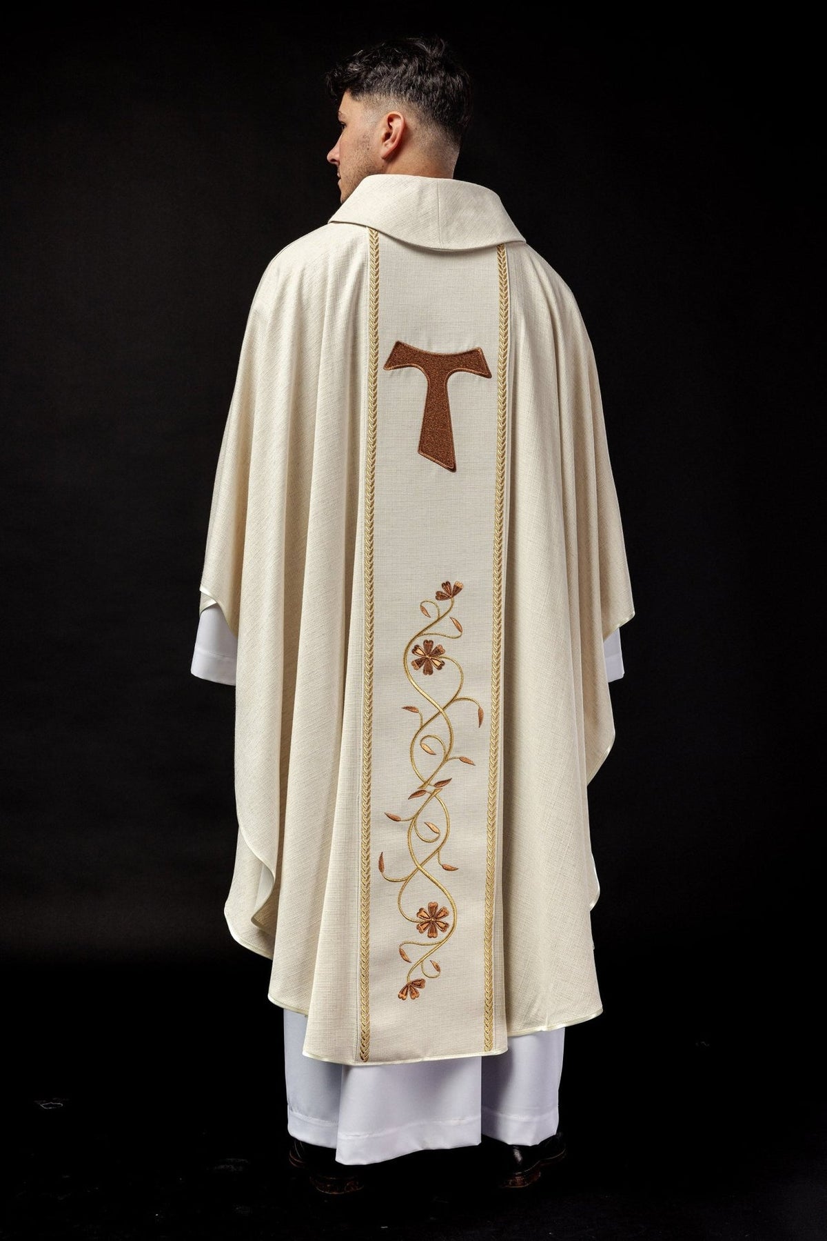 Chasuble back view showing brown Franciscan cross, gold trim and floral embroidery