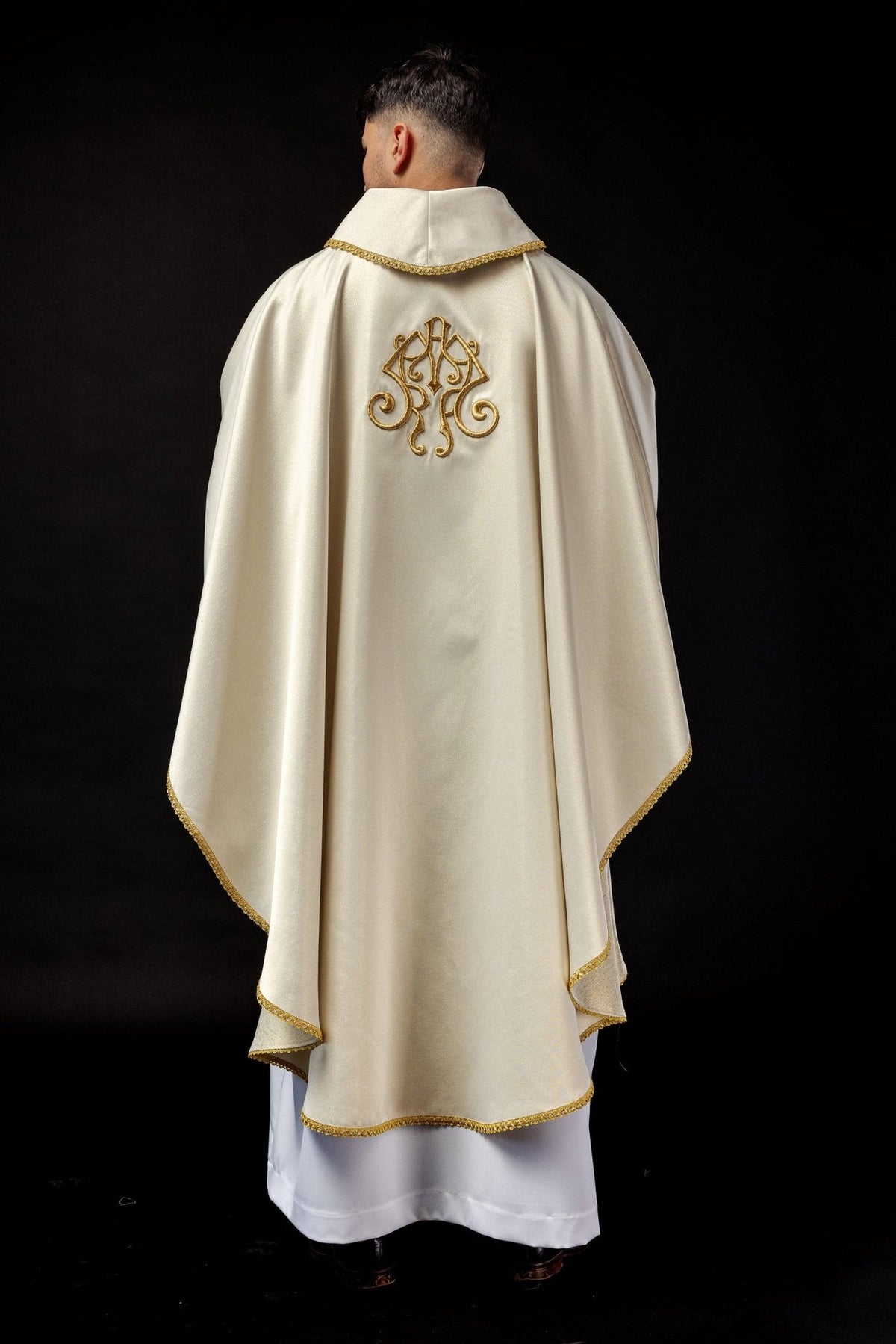 Candlemas chasuble back view in ivory with gold trim and embroidered monogram