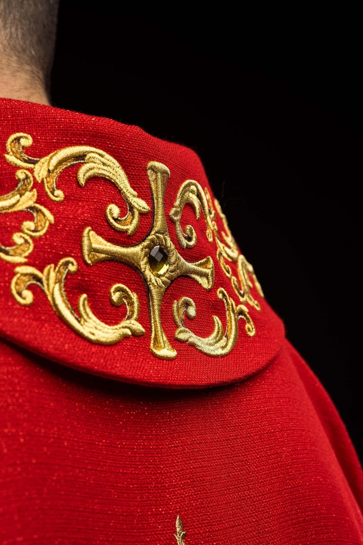 Red chasuble collar close-up with gold embroidery and cross detail