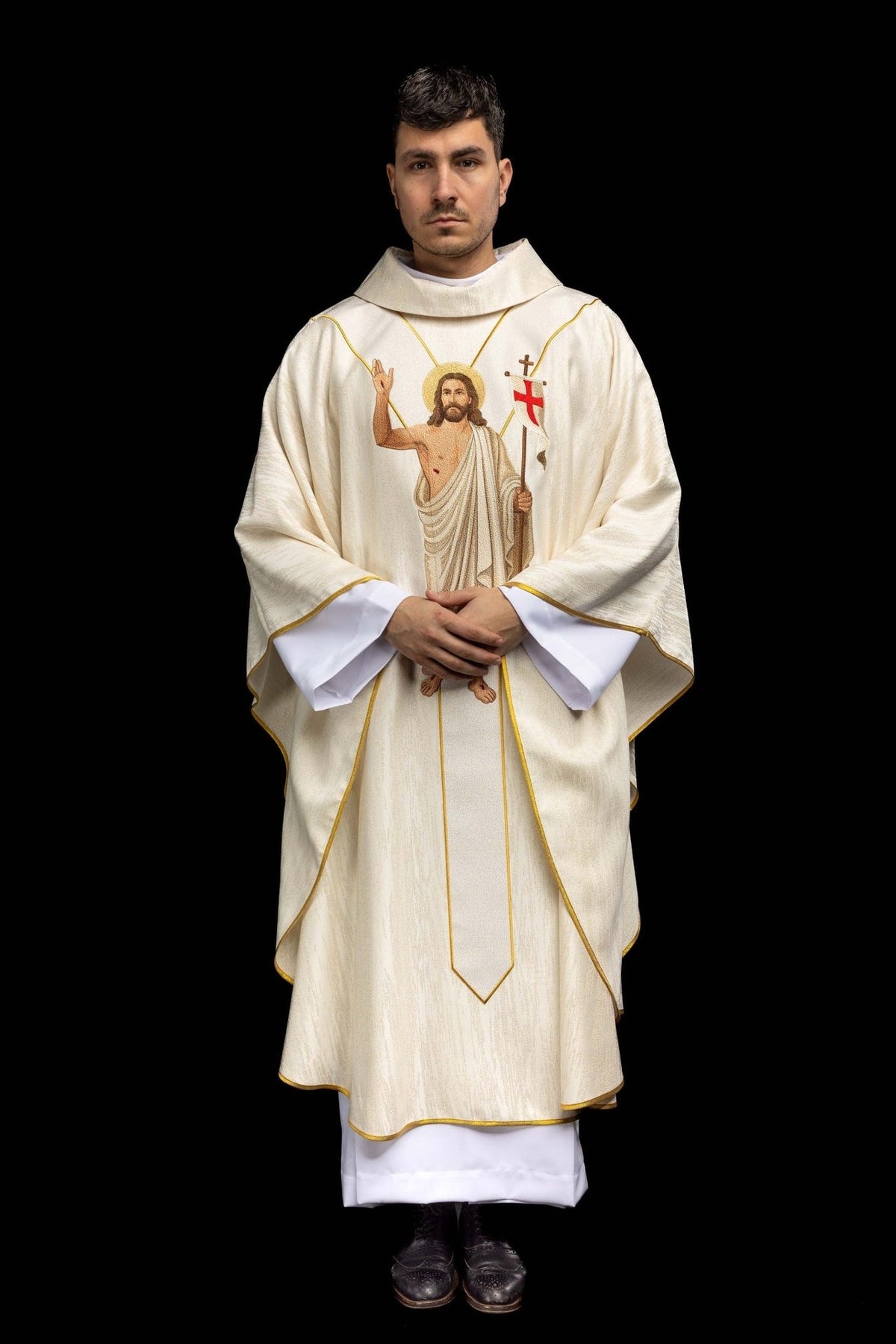 Chasuble front view worn, showing Risen Christ embroidery and gold-trimmed white fabric