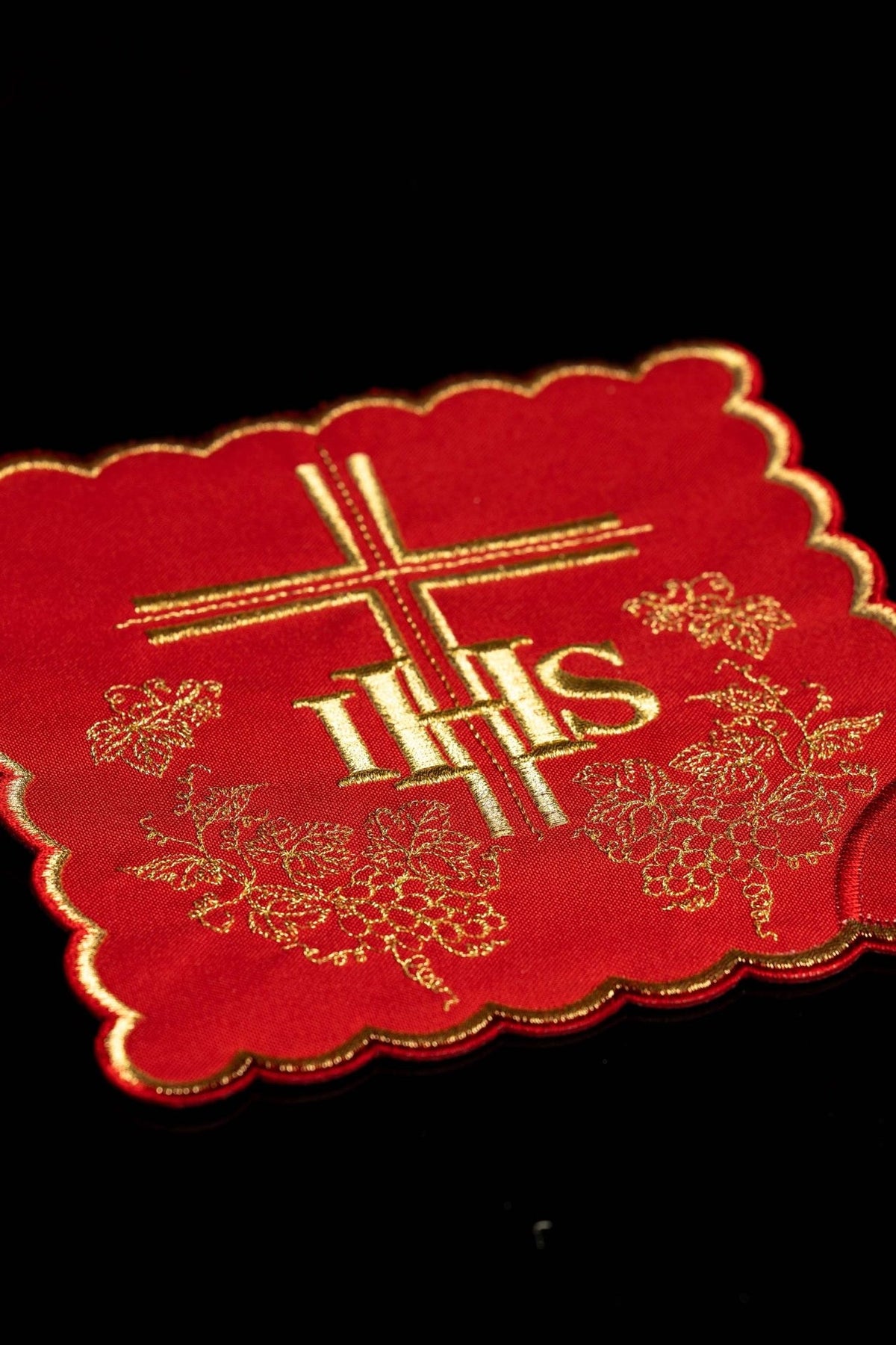 Red chalice pall close-up with gold IHS, cross and grape embroidery