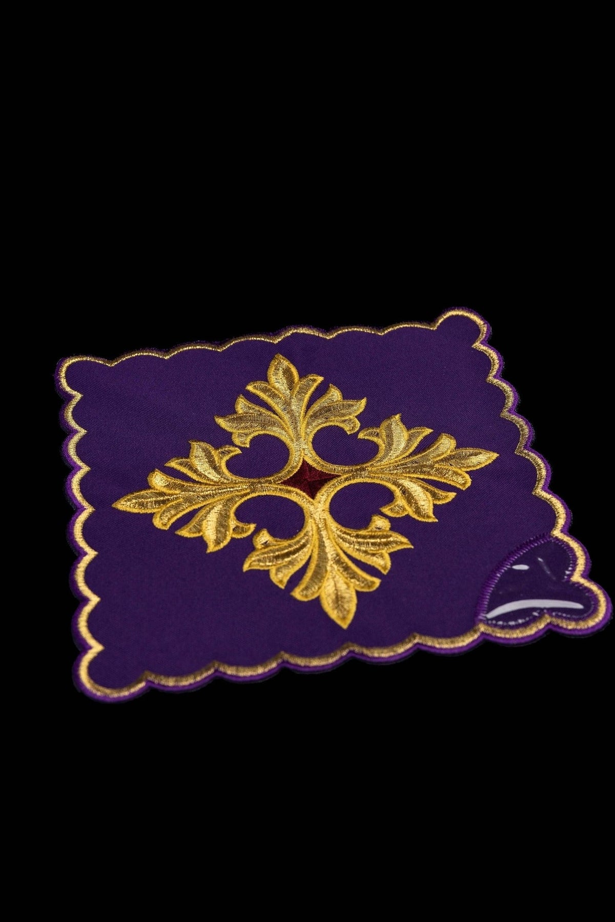 Purple chalice pall, angled view with gold embroidered cross and scalloped edge