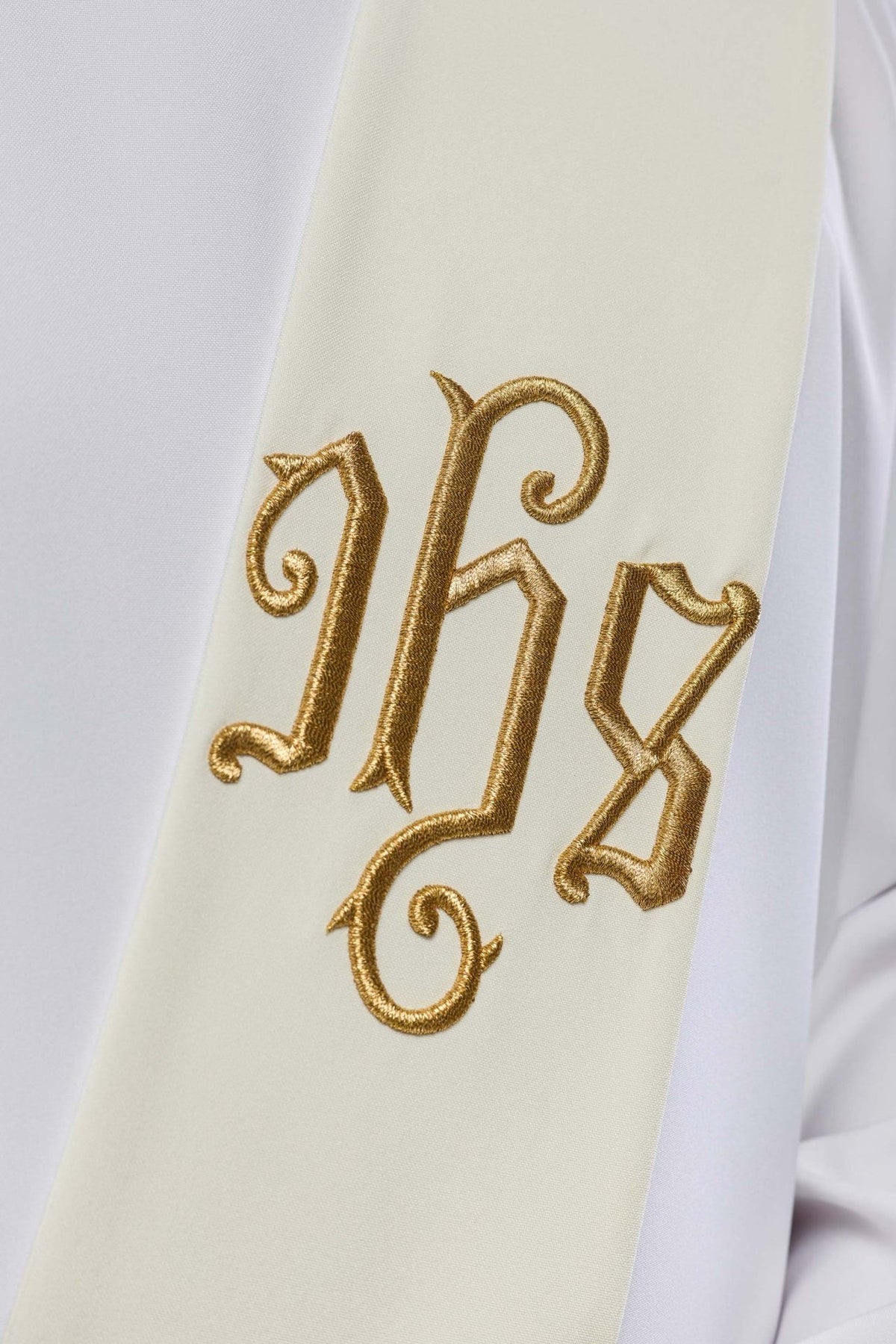 IHS deacon stole close-up with gold embroidered IHS monogram on ivory fabric