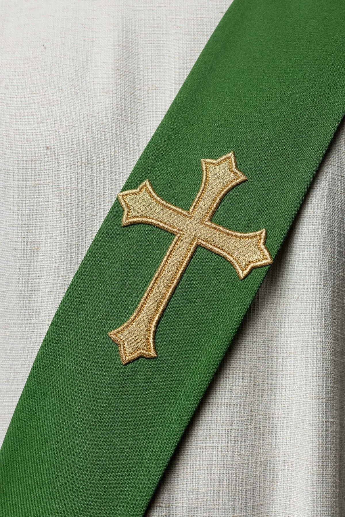 Green stole close-up showing the gold embroidered cross