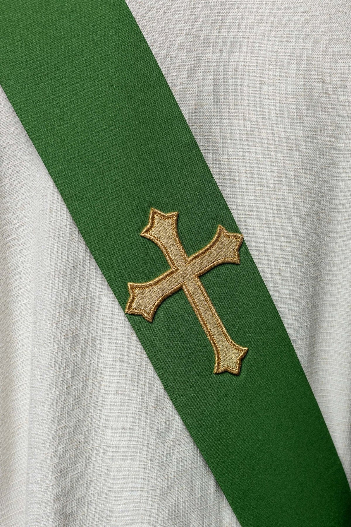 Green stole close-up showing the gold cross embroidery