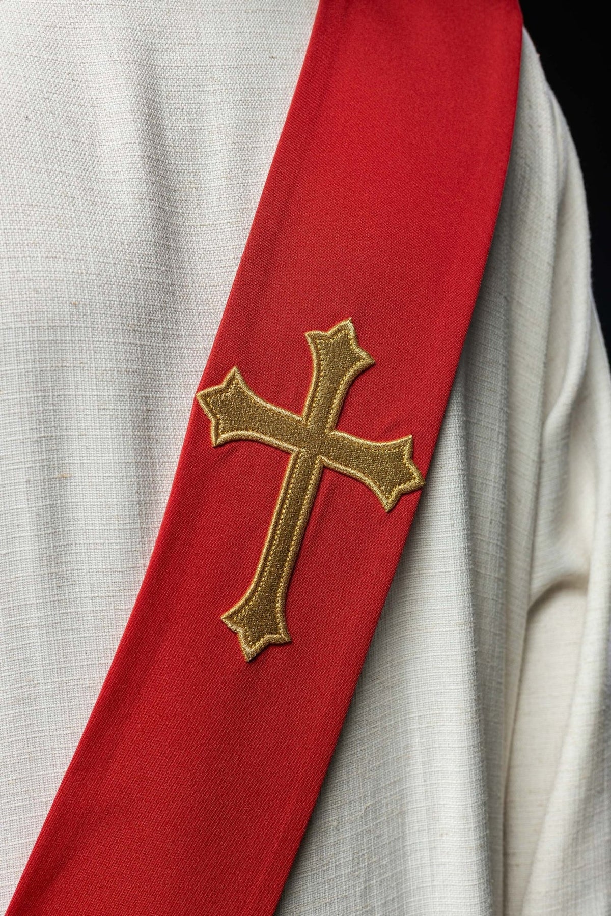Red stole close-up with embroidered gold cross