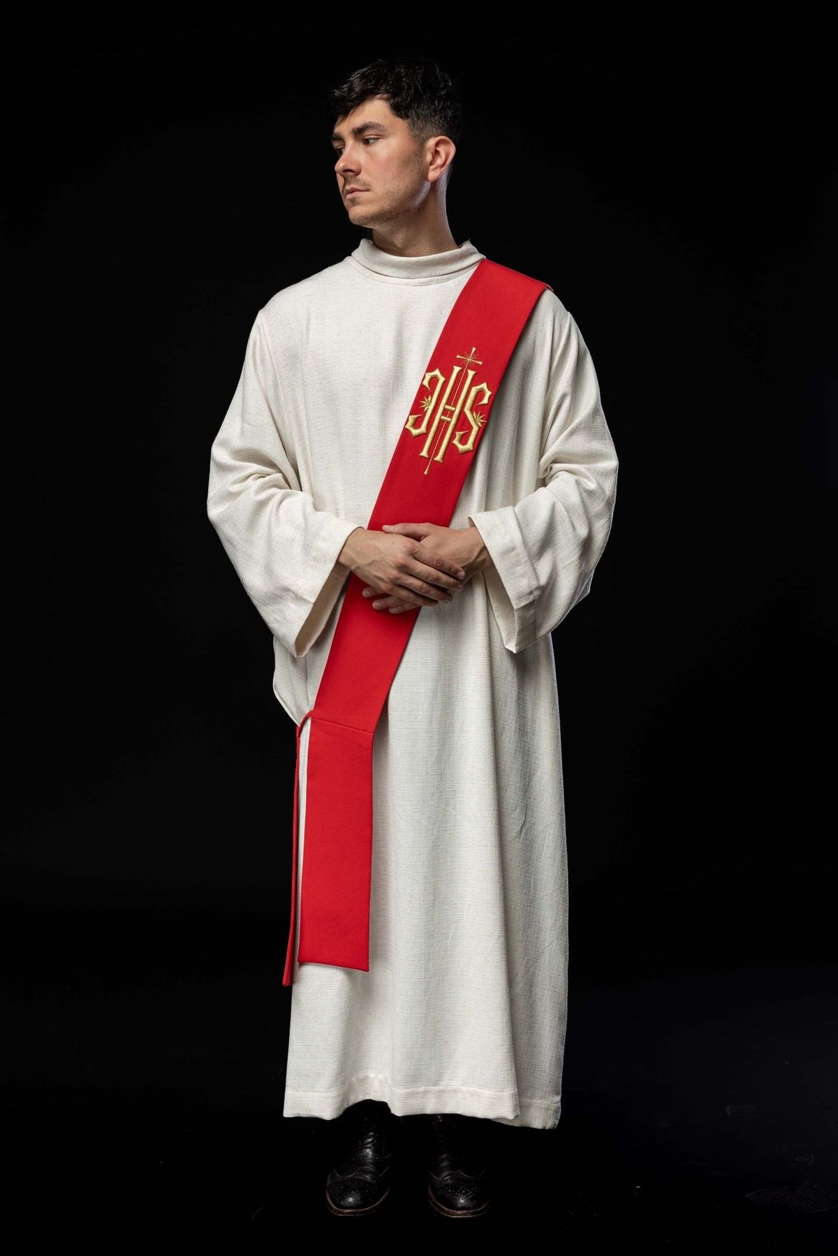 Red deacon stole worn in a full front view with gold IHS embroidery and cross