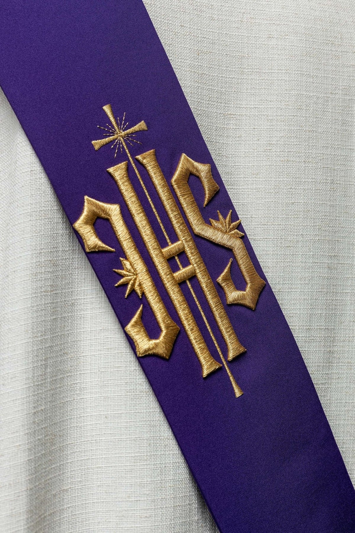 Close-up of purple stole with gold IHS and cross embroidery