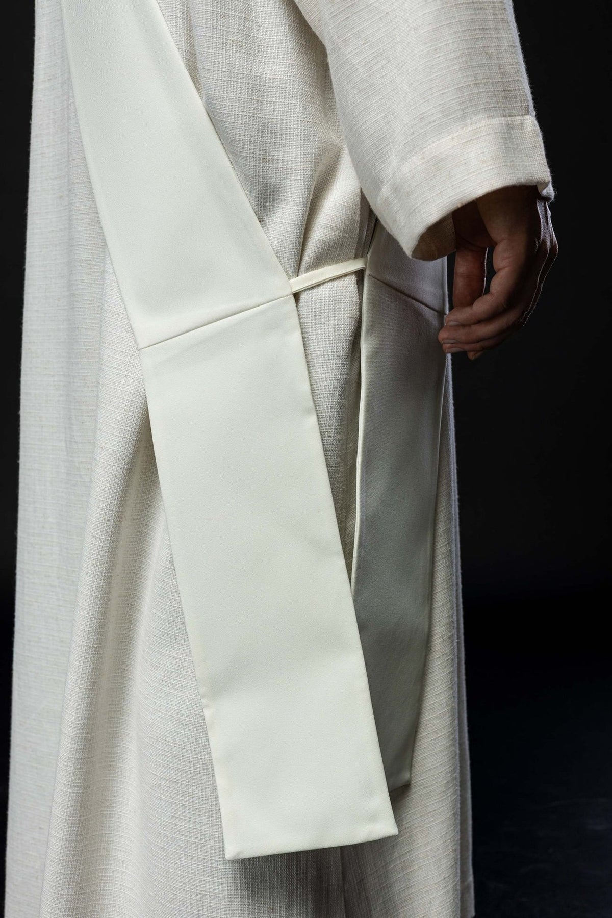 White deacon stole worn from the back, showing its plain reverse
