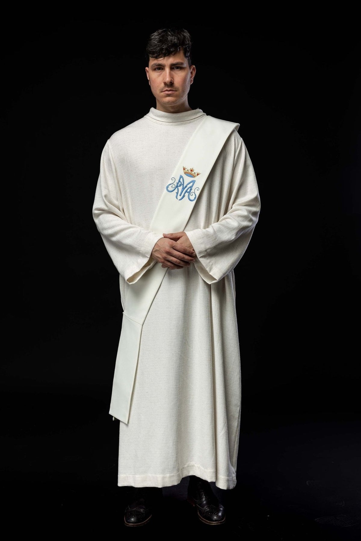 White Marian deacon stole worn from the front, showing its full length and embroidered Marian symbol