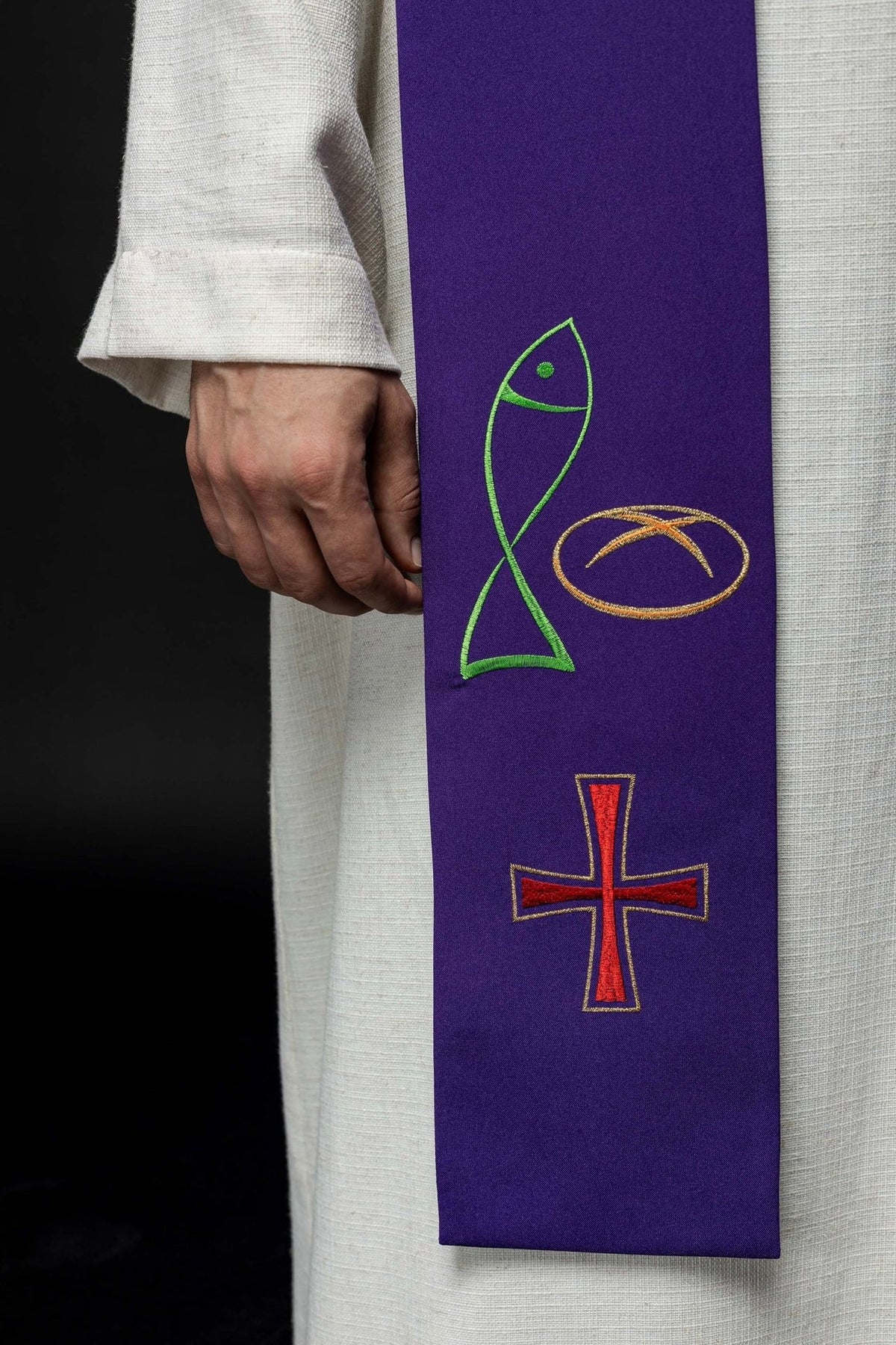 Purple priest stole close-up with embroidered fish, bread and cross