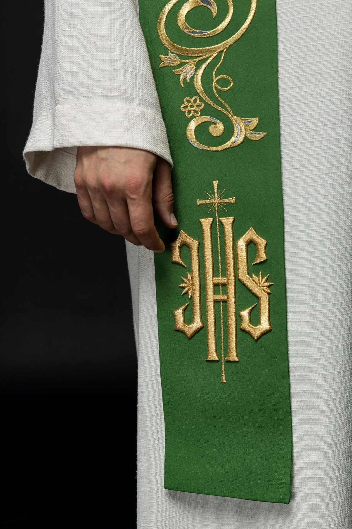 Green priest stole close-up showing gold scrollwork and IHS embroidery