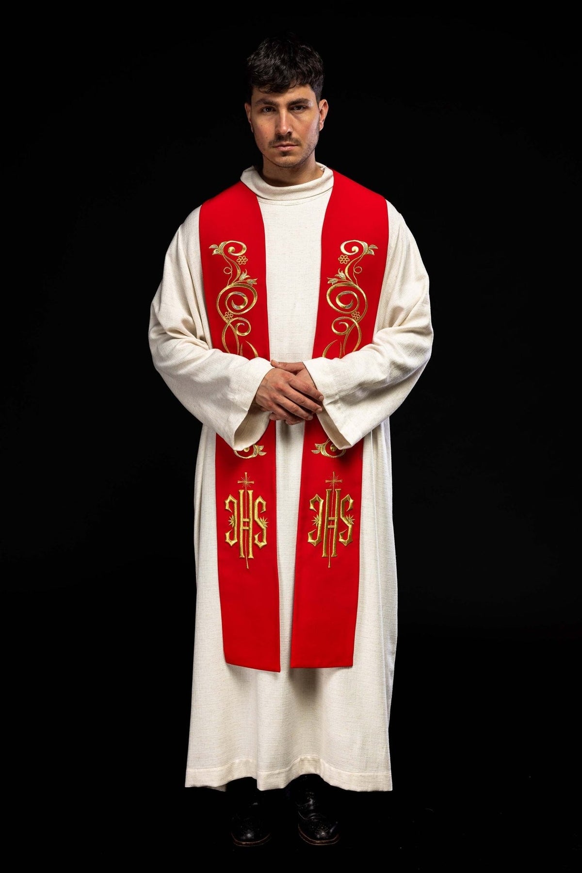 Red priest stole worn front view with gold embroidered scrollwork and IHS