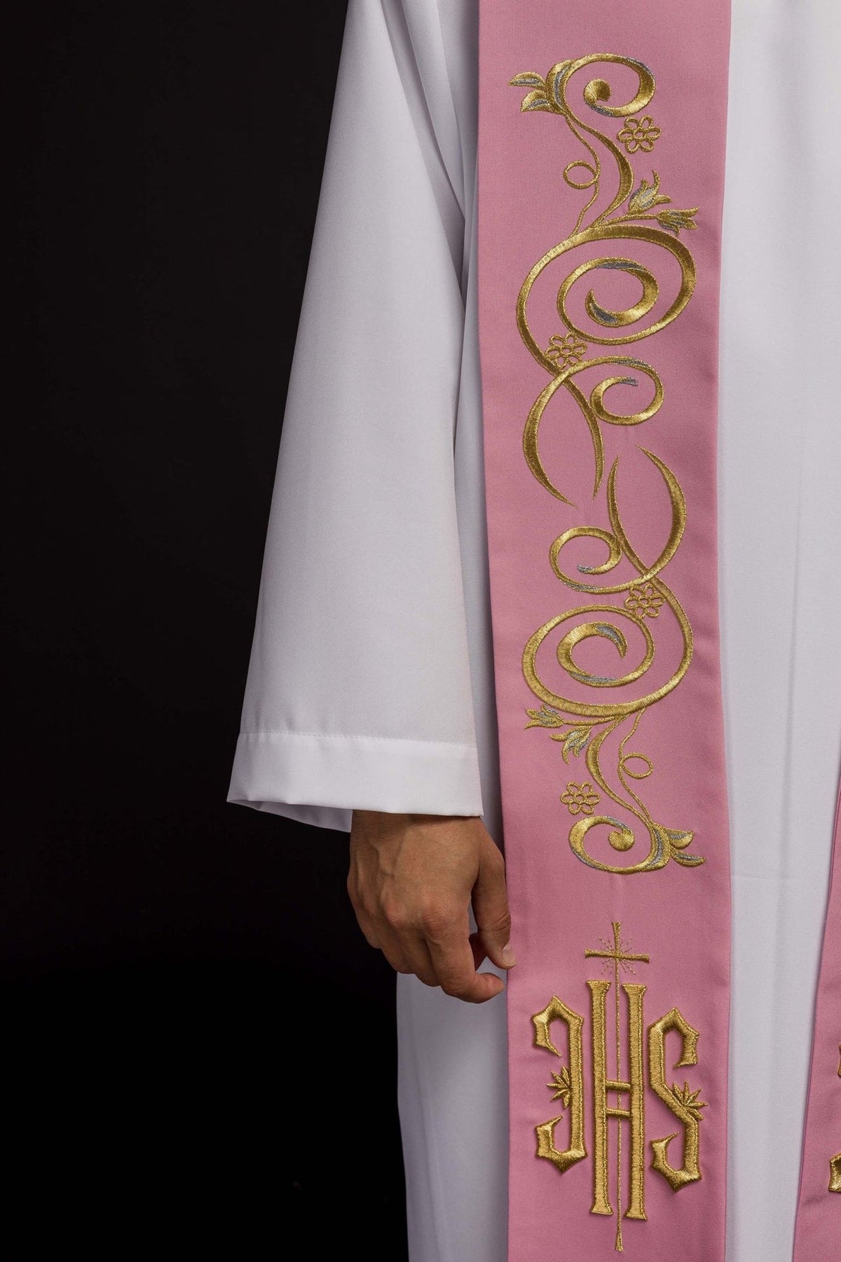 Pink stole close-up showing gold embroidery, floral scrollwork and IHS motif