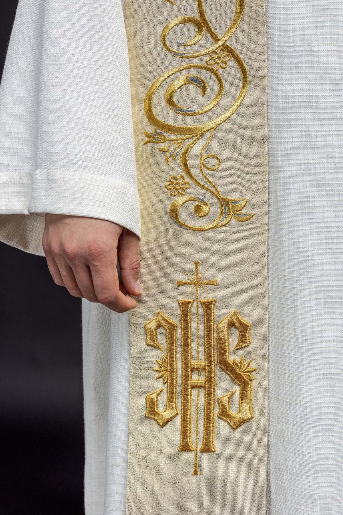 Gold Catholic stole close-up showing gold scroll embroidery and IHS motif