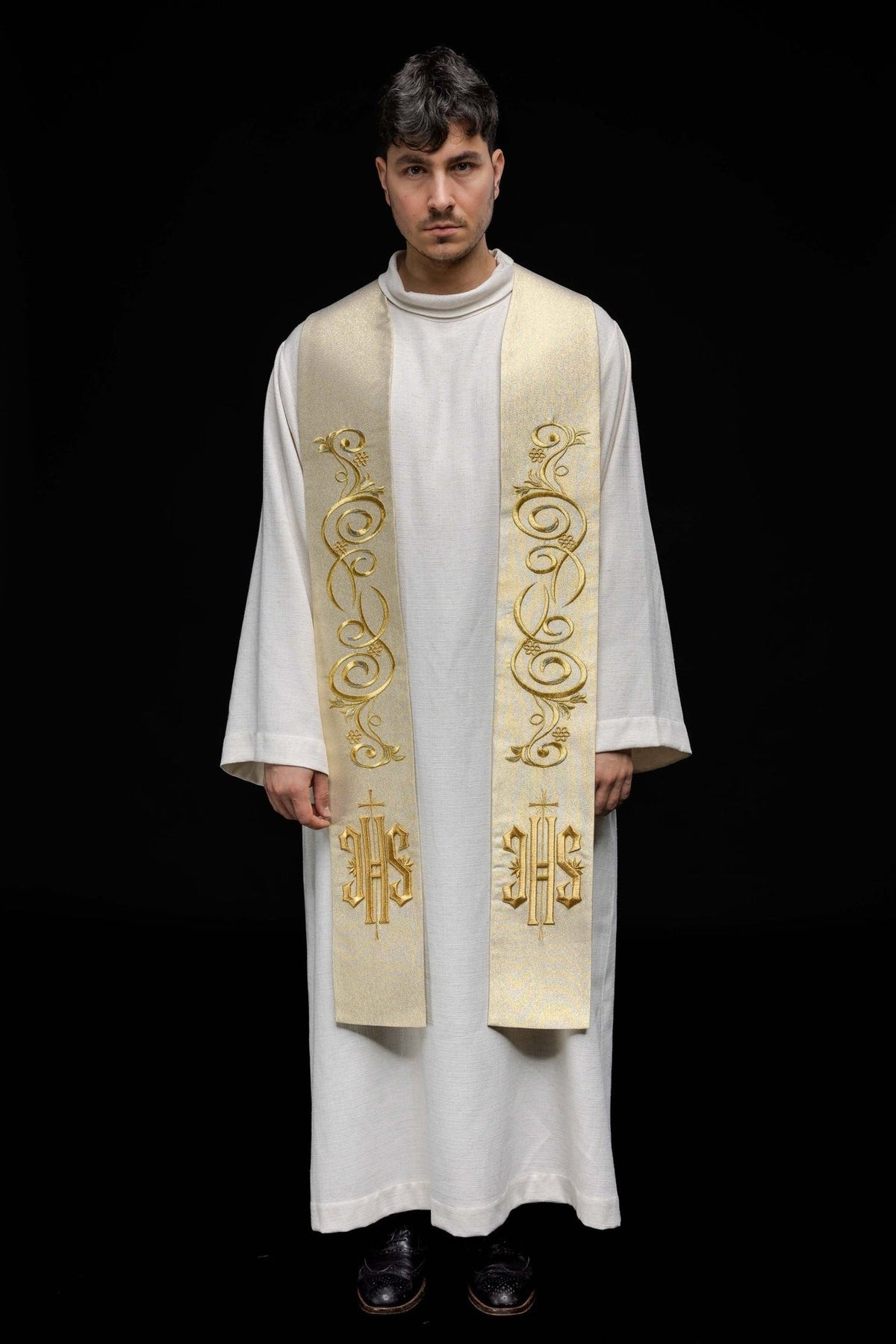Gold Catholic stole worn front view showing scroll embroidery and IHS motifs