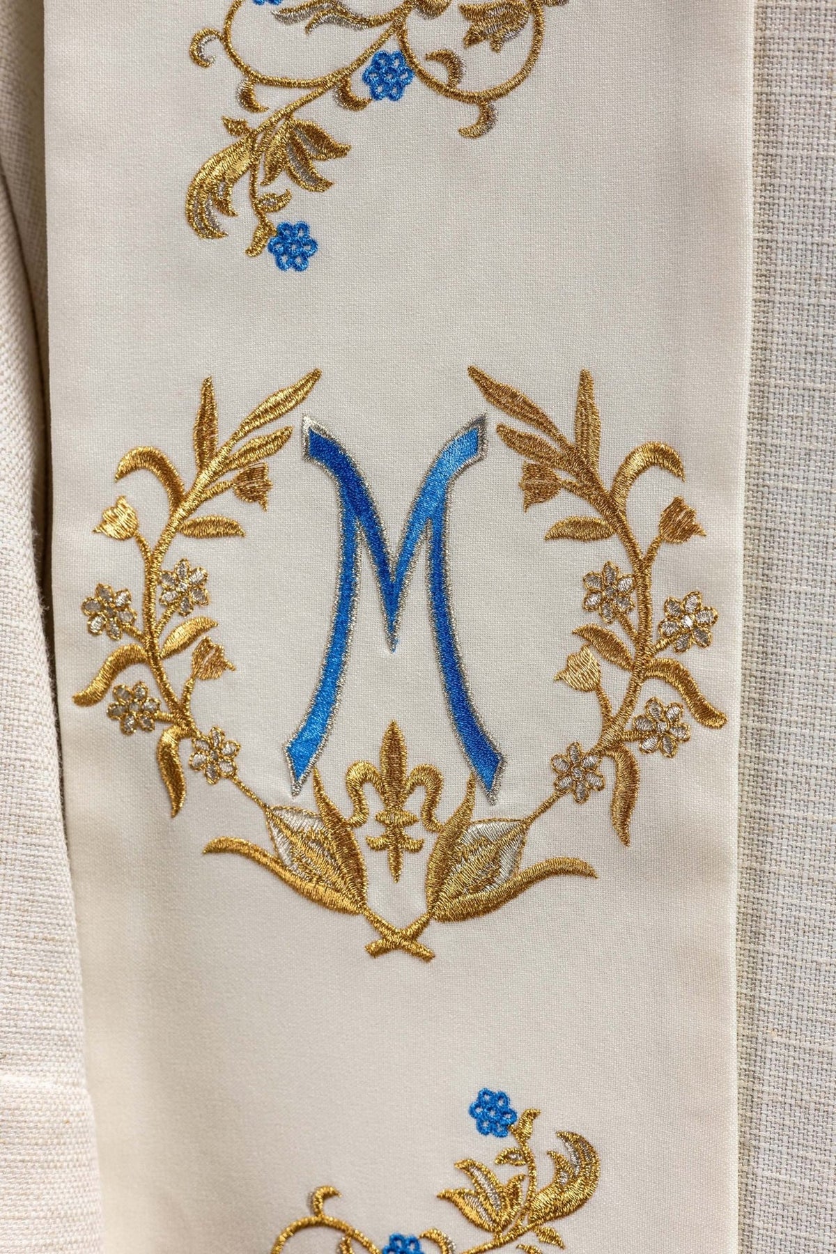 Marian stole close-up with ecru fabric, gold embroidery and blue Marian symbol