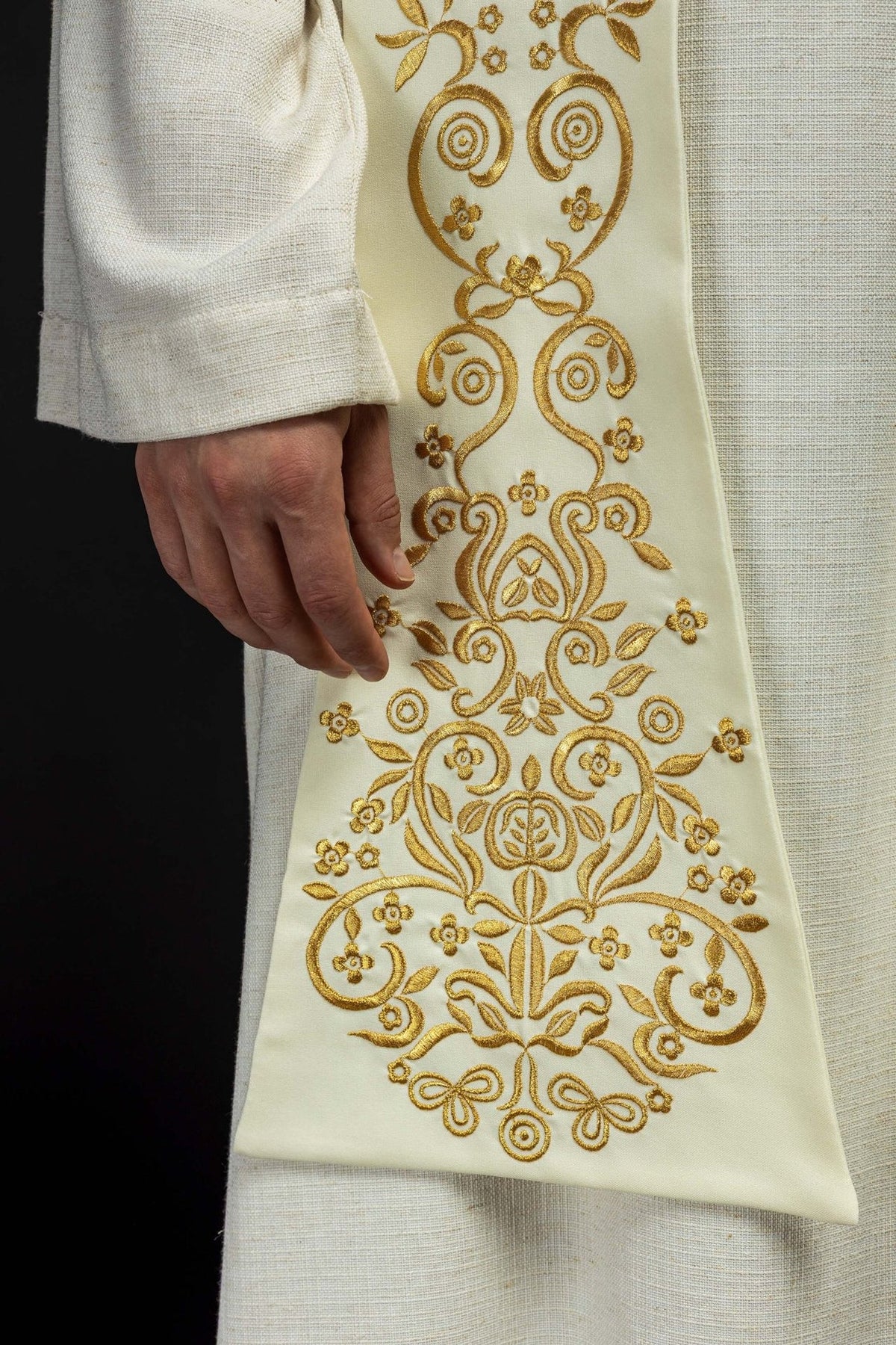 Ecru stole close-up showing ornate gold embroidered floral and scroll motifs