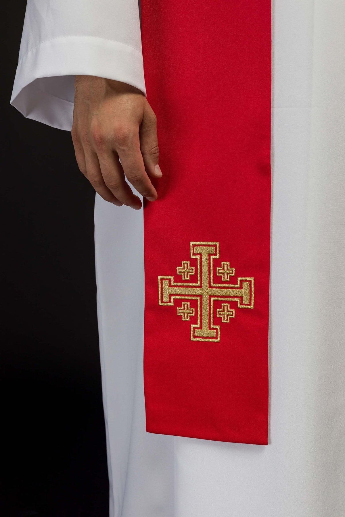 Red embroidered priest stole close-up showing a gold Jerusalem cross